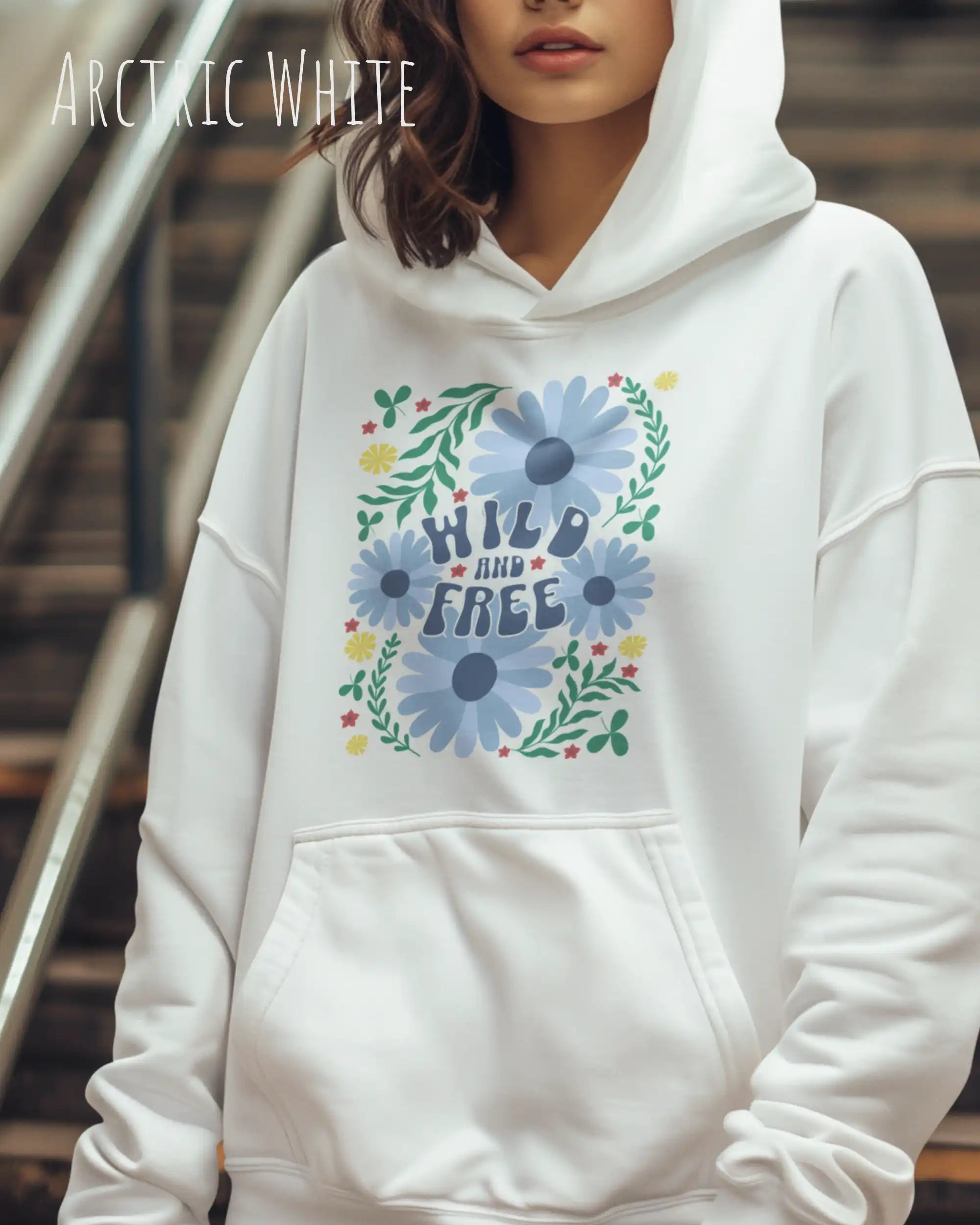 Eine Frau trägt einen Oversized Design-Hoodie in arctoc white mit dem Statement wild and free,