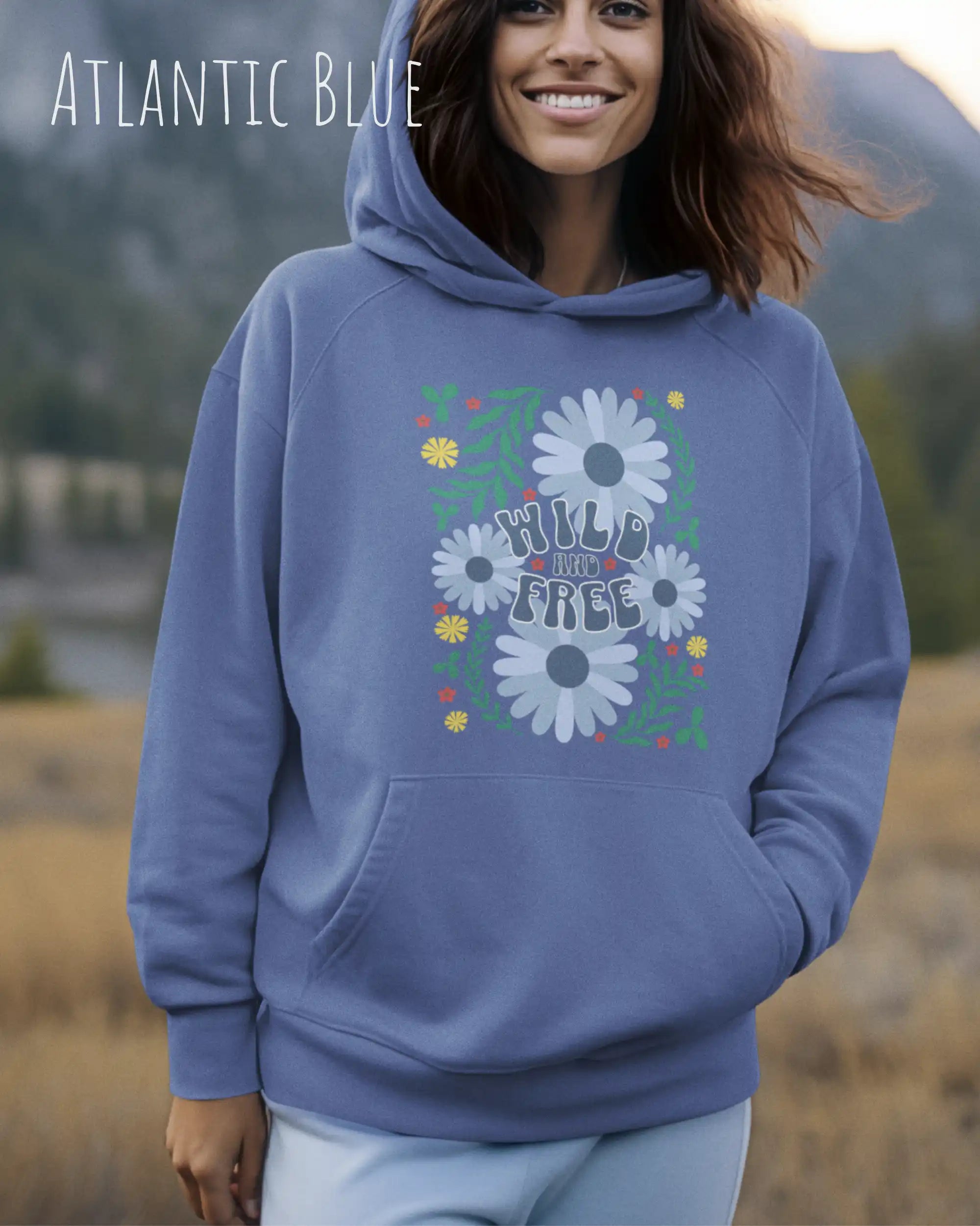 Eine Frau trägt einen Oversized Design-Hoodie in atlantic blue  mit dem Statement wild and free,