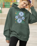 Eine Frau trägt einen Oversized Design-Hoodie in moss green mit dem Statement wild and free,