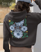 Eine Frau trägt einen Oversized Design-Hoodie in deep black mit dem Backprint-Statement wild and free,