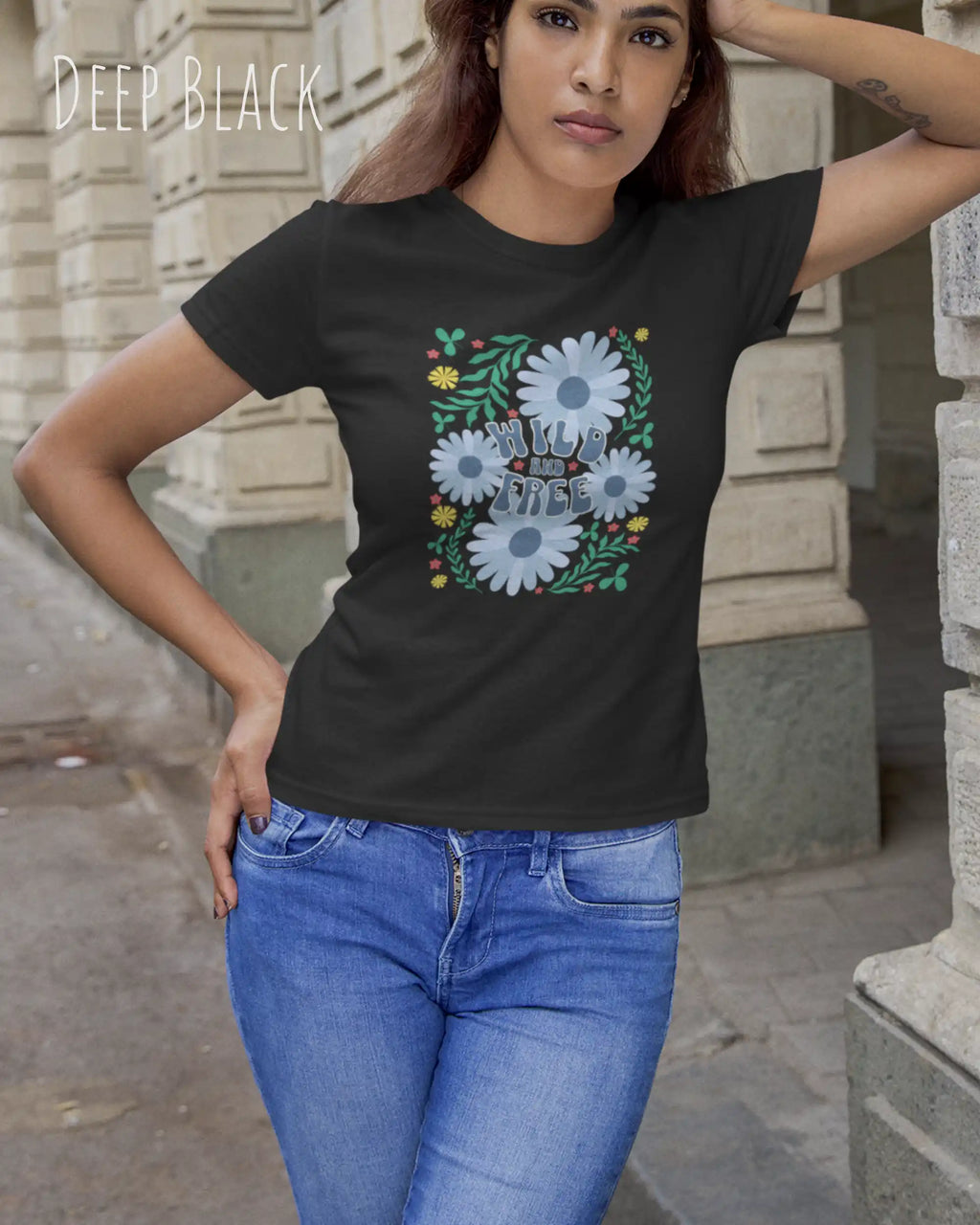 Junge frau beim klettern trägt ein feminines Basic Design-T‑Shirt  in der farbe deep black mit dem motiv WILD AND FREE.