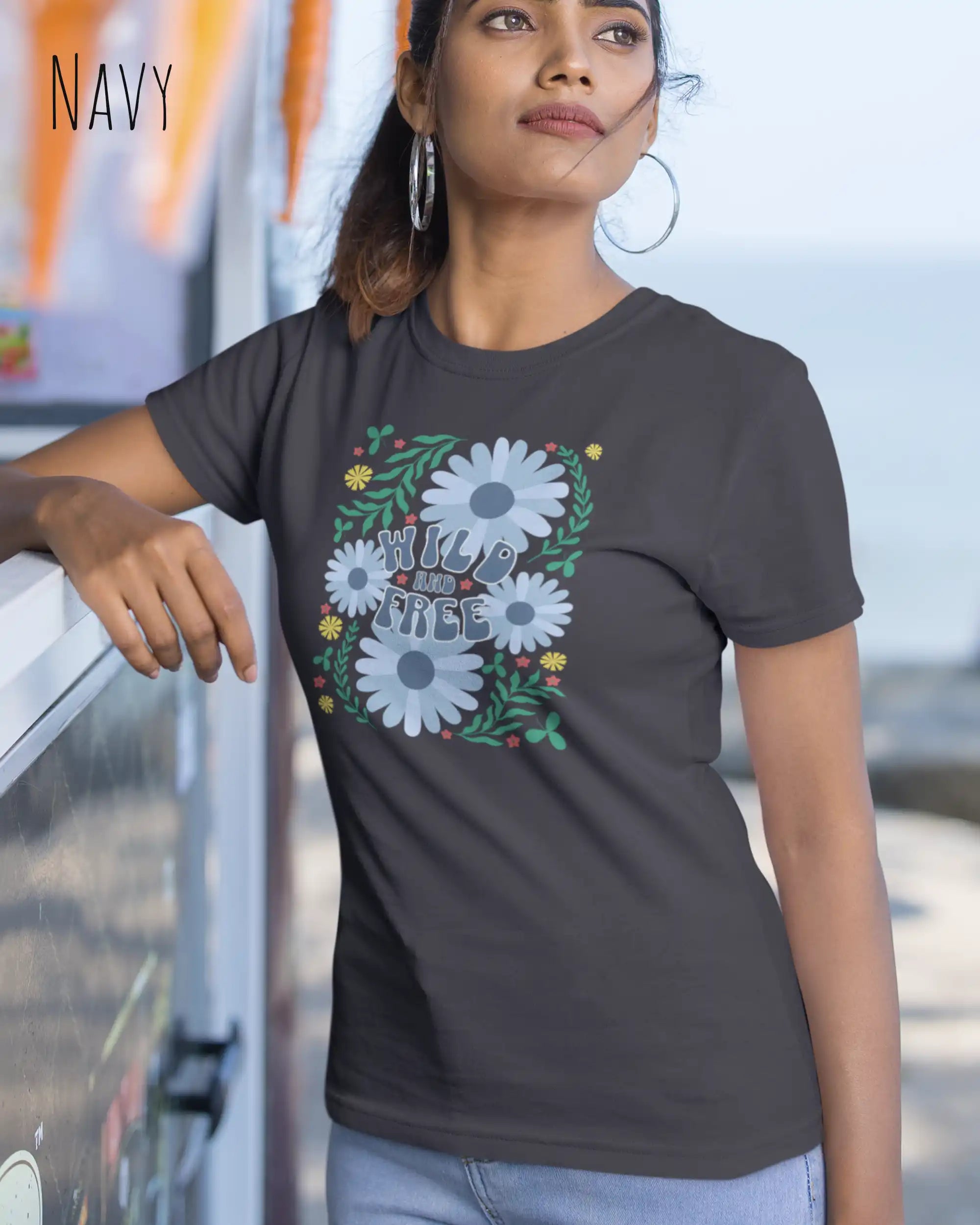 Junge frau beim klettern trägt ein feminines Basic Design-T‑Shirt  in der farbe navy mit dem motiv WILD AND FREE.