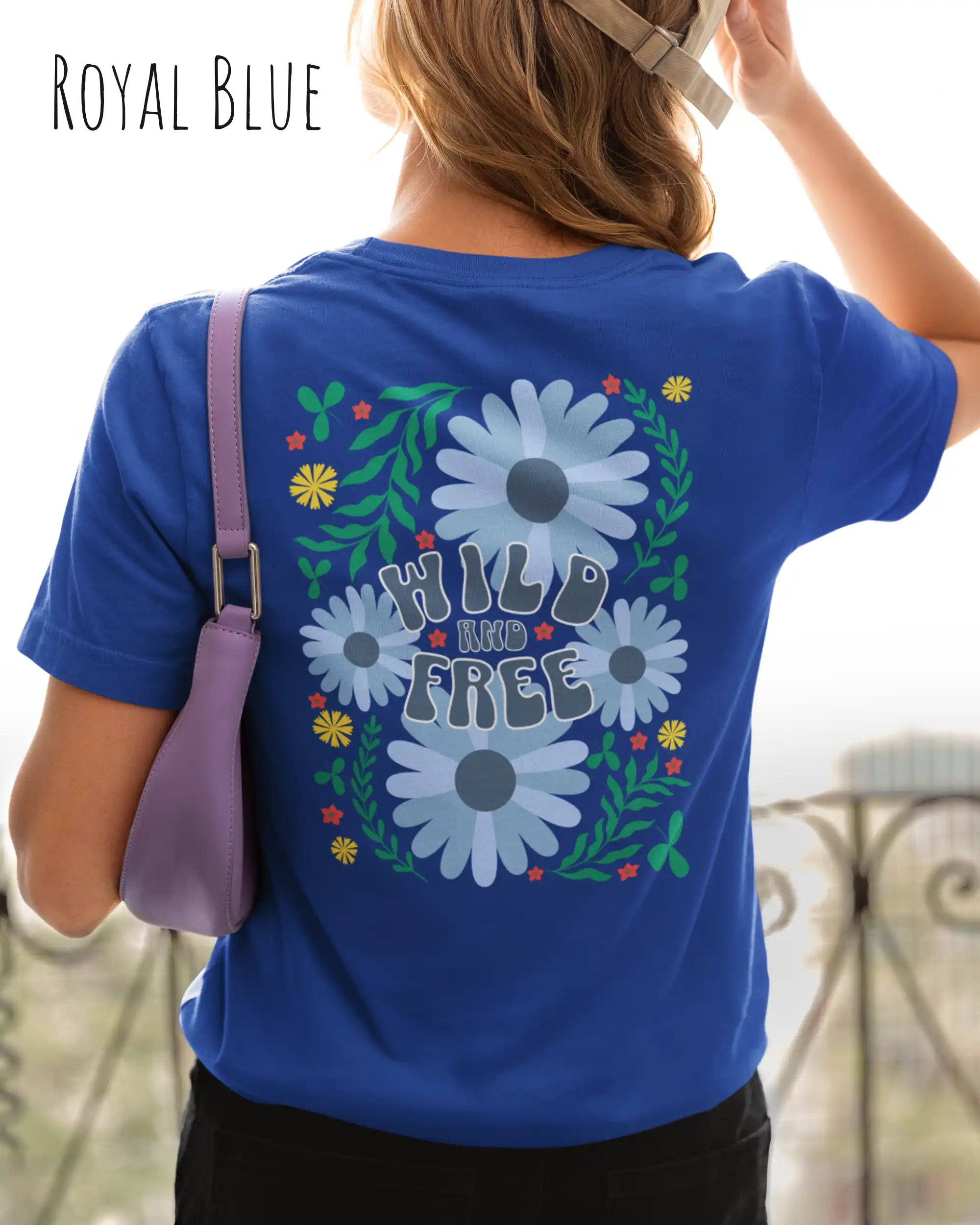 frau trägt ein design-t-shirt in der farbe royal blue mit dem motiv wild and free im modernisierten boho-style.