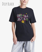 Blonde Frau trägt das Baumwolle Unisex T-Shirt AWDis 150 T in der Farbe DEEP BLACK mit dem STATEMENT Design DON’T TALK JUST ACT
