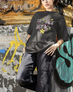 JUNGE FRAU trägt das Heavyweight Oversized T-Shirt AWDis 240 T in der Farbe DEEP BLACK mit dem STATEMENT Design DON’T TALK JUST ACT