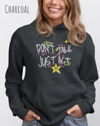 Eine frau trägt einen oversized design hoodie in der farbe charcoal mit dem statement don't talk just act.