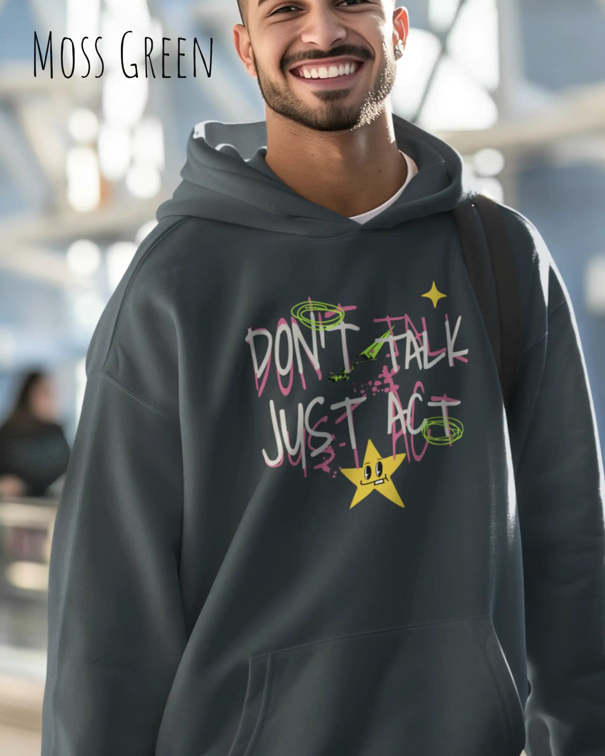 Ein Mann trägt einen oversized design hoodie in der farbe moss green mit dem statement don't talk just act.
