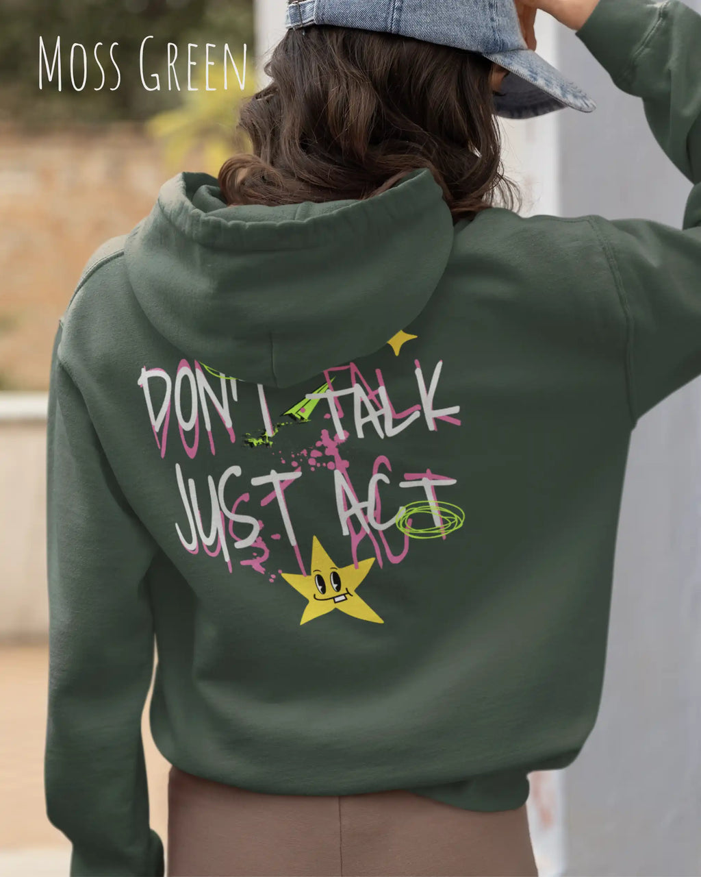 Eine Frau  trägt einen oversized design hoodie in der farbe moss green mit dem backprint statement don't talk just act.