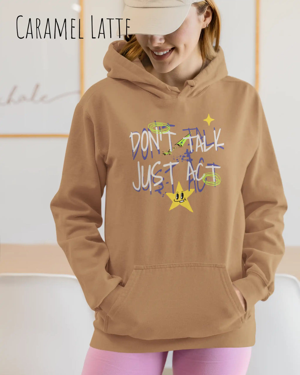 EINE FRAU TRÄGT einen design hoodie in der Farbe caramel latte mit dem STATEMENT don't talk just act,