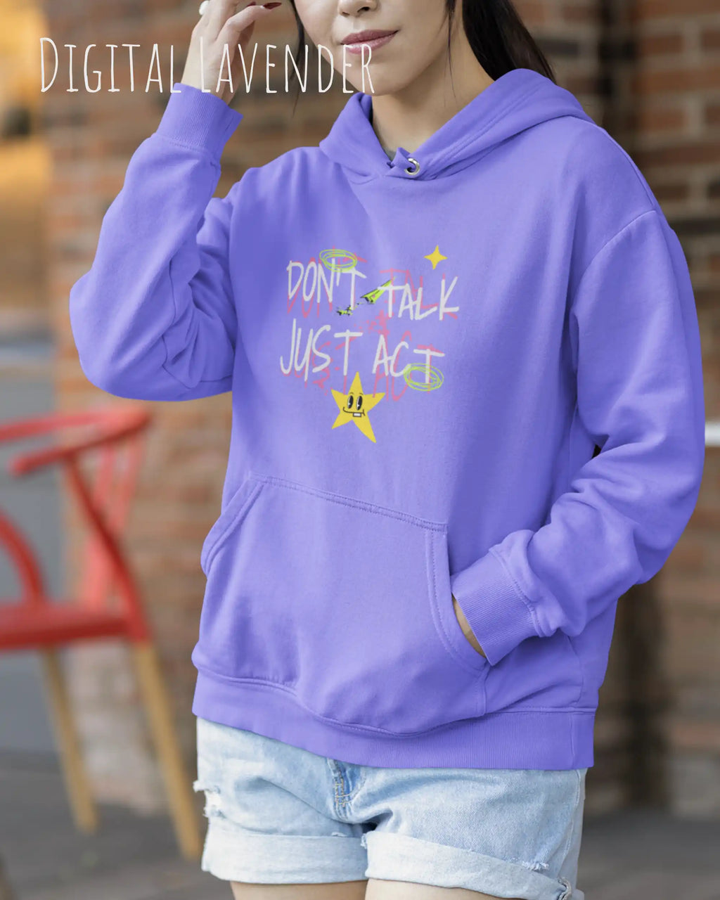 EINE FRAU TRÄGT einen design hoodie in der Farbe dusty lilac mit dem STATEMENT don't talk just act,