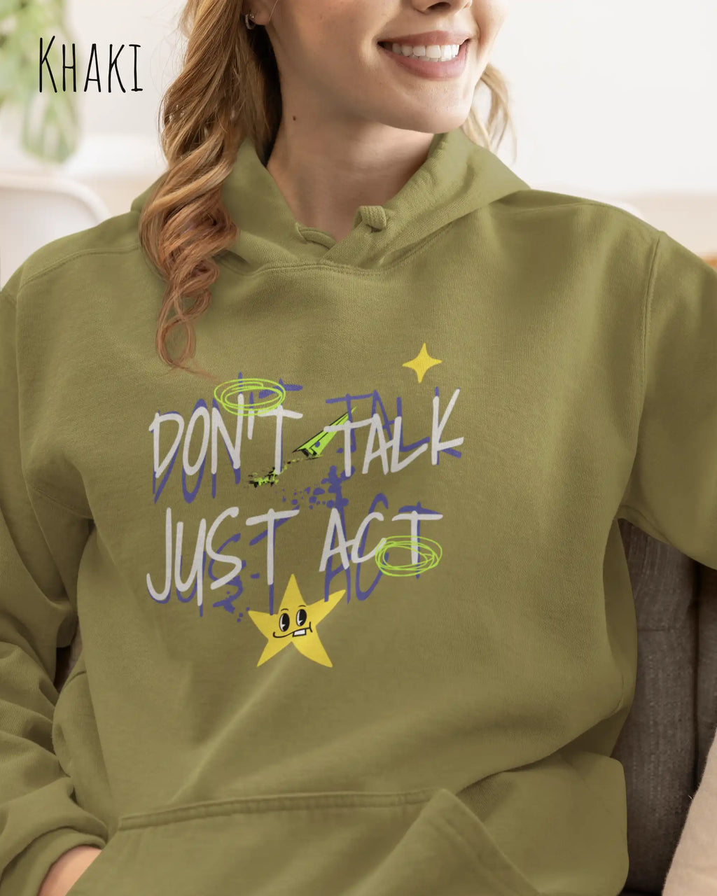 EINE FRAU TRÄGT einen design hoodie in der Farbe khaki mit dem STATEMENT don't talk just act,
