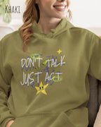 EINE FRAU TRÄGT einen design hoodie in der Farbe khaki mit dem STATEMENT don't talk just act,