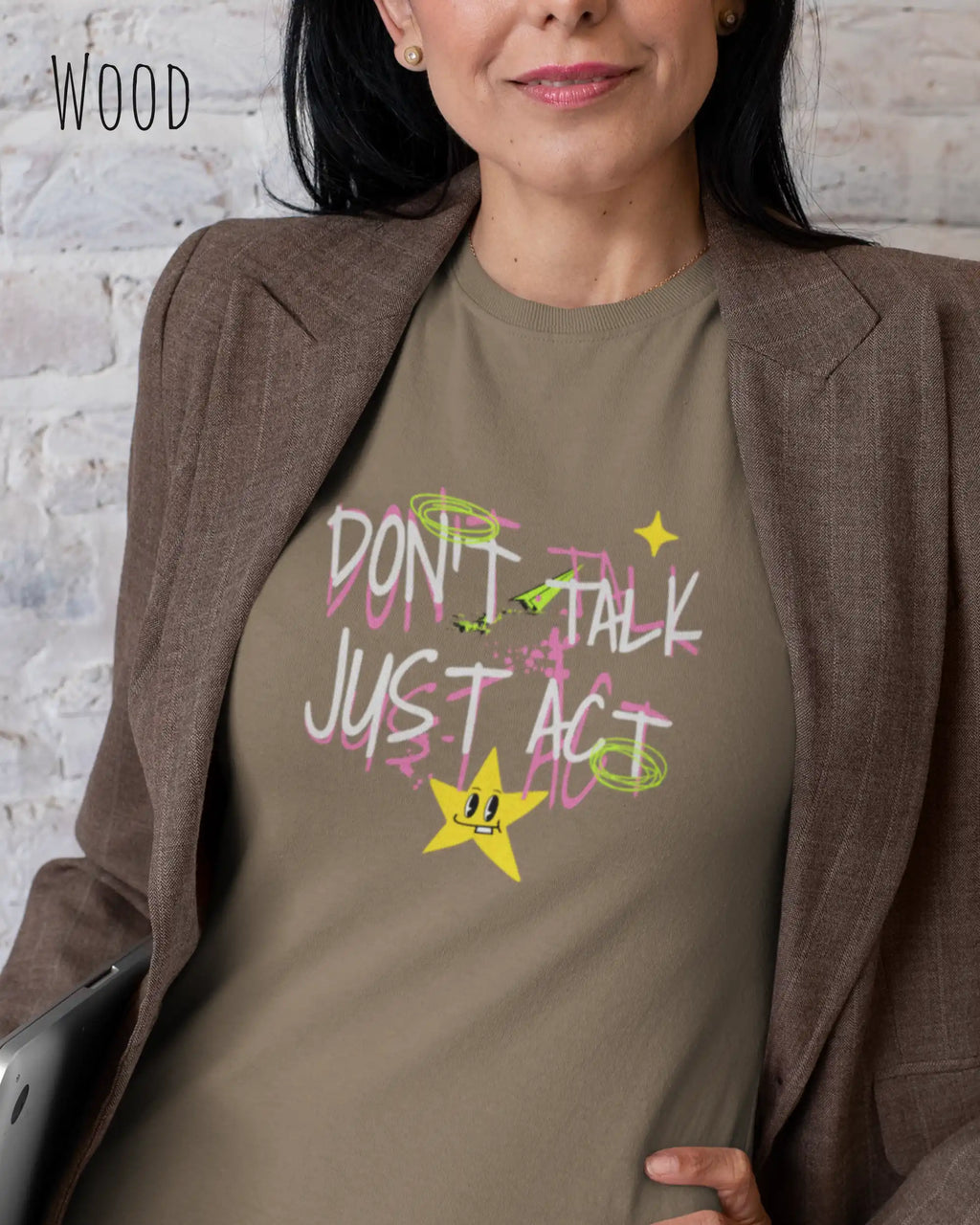 die Abbildung zeigt eine frau, die ein feminines Design-T-Shirt in der farbe wood mit dem design "Don't talk Just Act" unter dem blazer trägt.