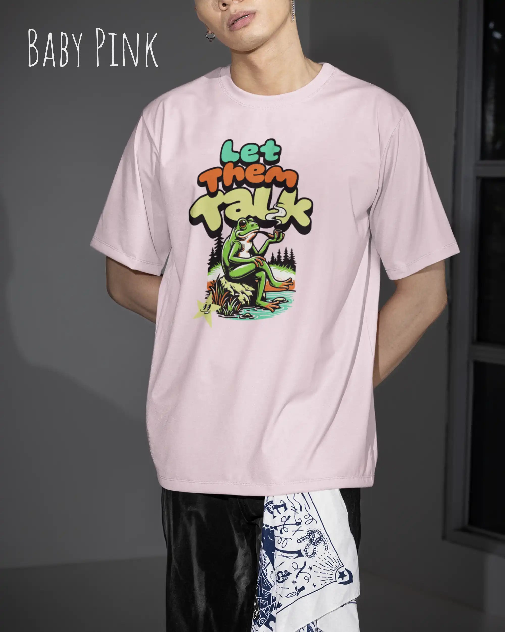 Die Abbildung zeigt eine frau  mit einem Design-T-Shirt in der Farbe baby pink und mit der Grafik let them talk.