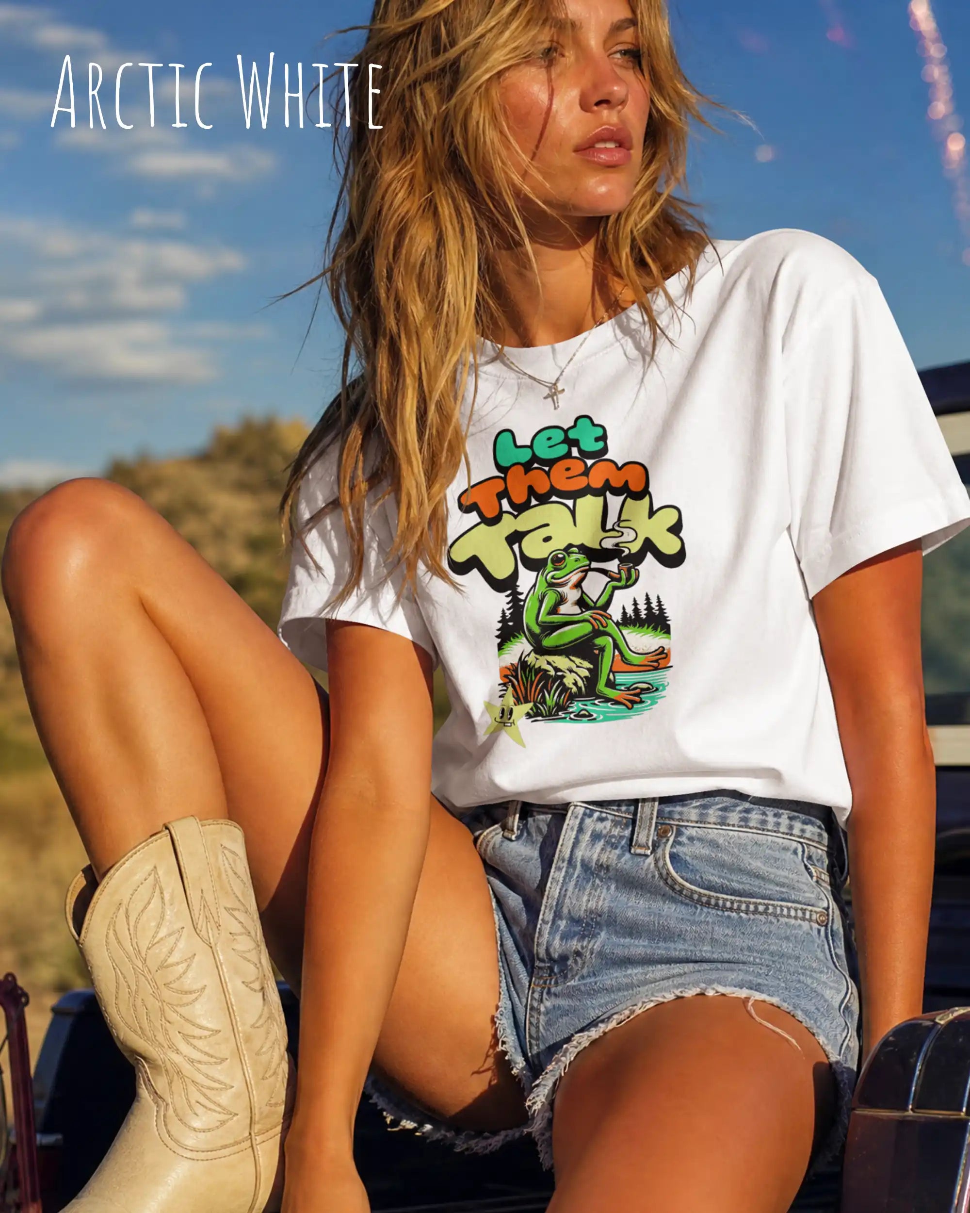 blonde frau trägt ein oversized heavyweight design-t-shirt in der farbe arctic white mit dem entspannten motiv let them talk - lass sie reden. 