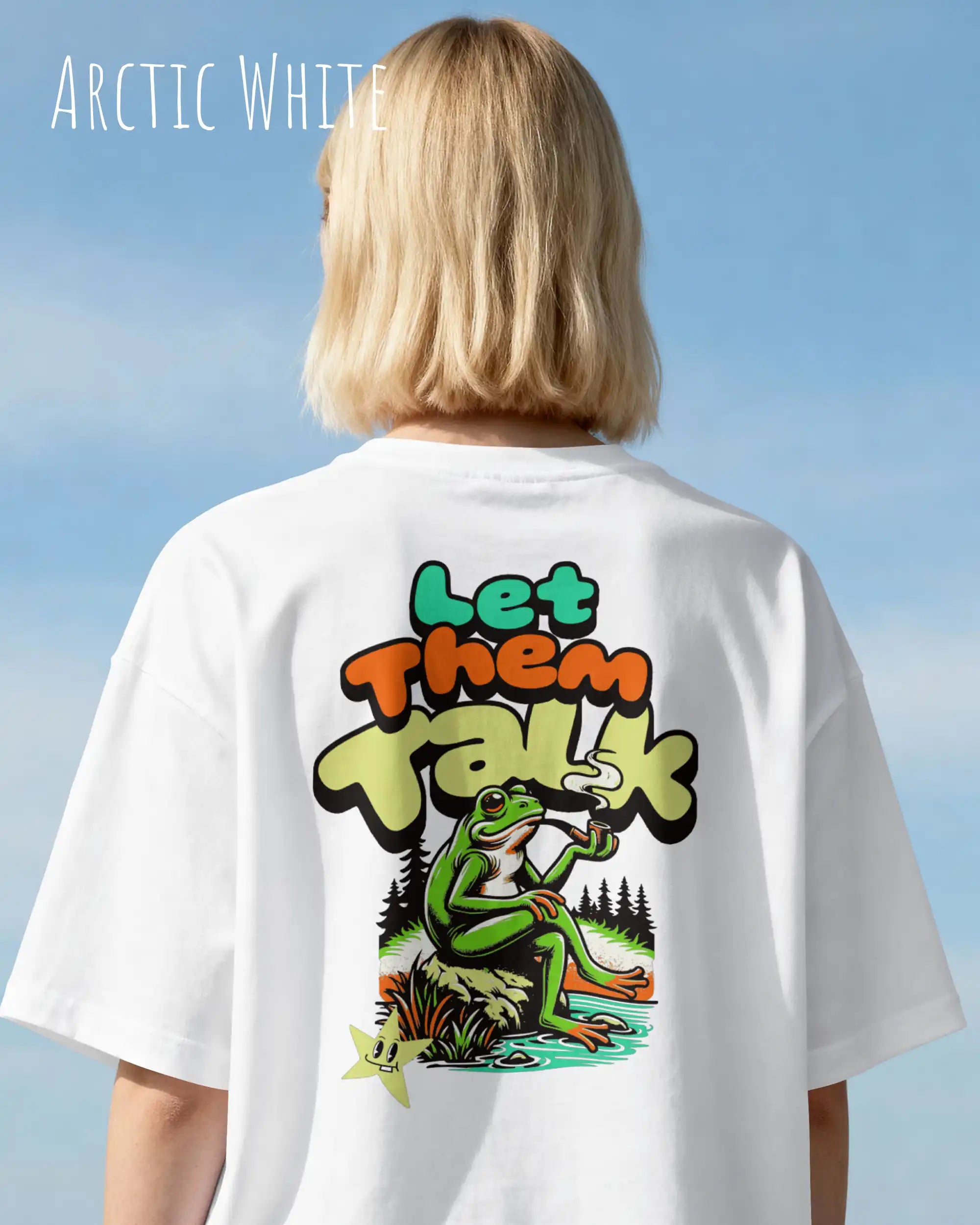 blonde frau trägt ein oversized heavyweight design-t-shirt in der farbe arctic white mit dem entspannten backprint let them talk - lass sie reden. 