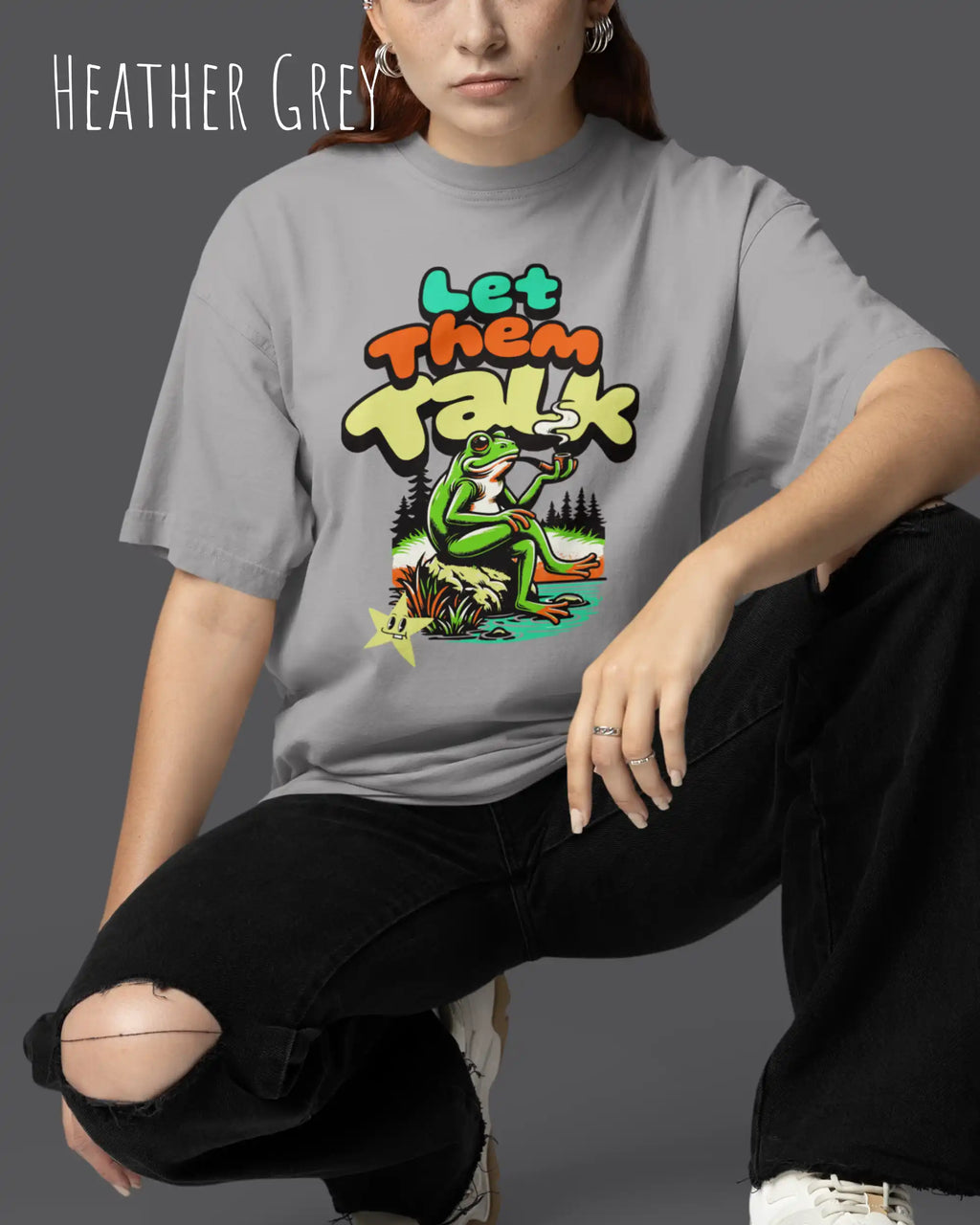 junge frau trägt ein oversized heavyweight design-t-shirt in der farbe heather grey mit dem entspannten motiv let them talk - lass sie reden. 
