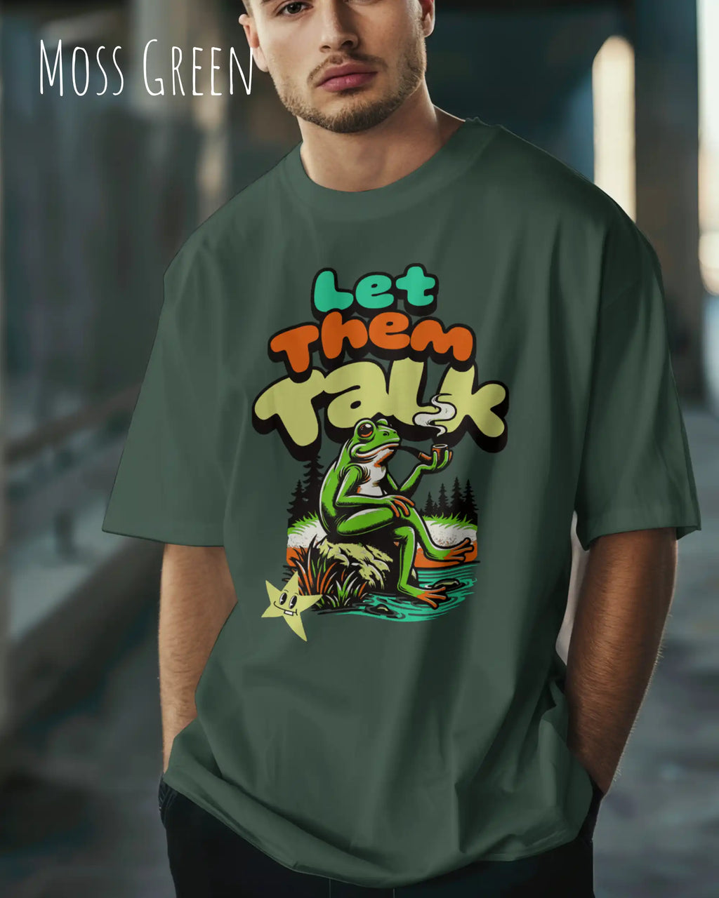 junger mann trägt ein oversized heavyweight design-t-shirt in der farbe moss green mit dem entspannten motiv let them talk - lass sie reden. 