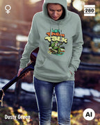Das bild zeigt eine frau, die  einen Damen-Design-Hoodie in der farbe dusty green mit dem humorvollen motiv "let them talk" trägt.