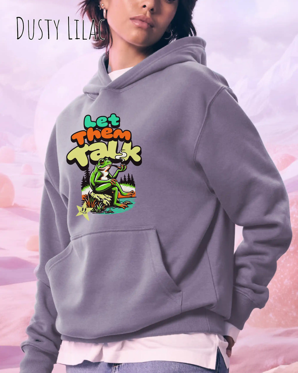 die Abbildung zeigt eine frau, die einen Oversized Design-Hoodie in der farbe dusty lilac und mit dem humorvollen motiv "let them talk" trägt.
