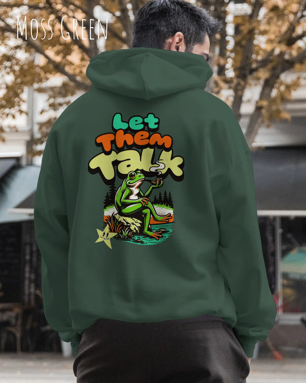 die Abbildung zeigt einen mann, der einen Oversized Design-Hoodie in der farbe moss green und mit dem humorvollen backprint "let them talk" trägt.