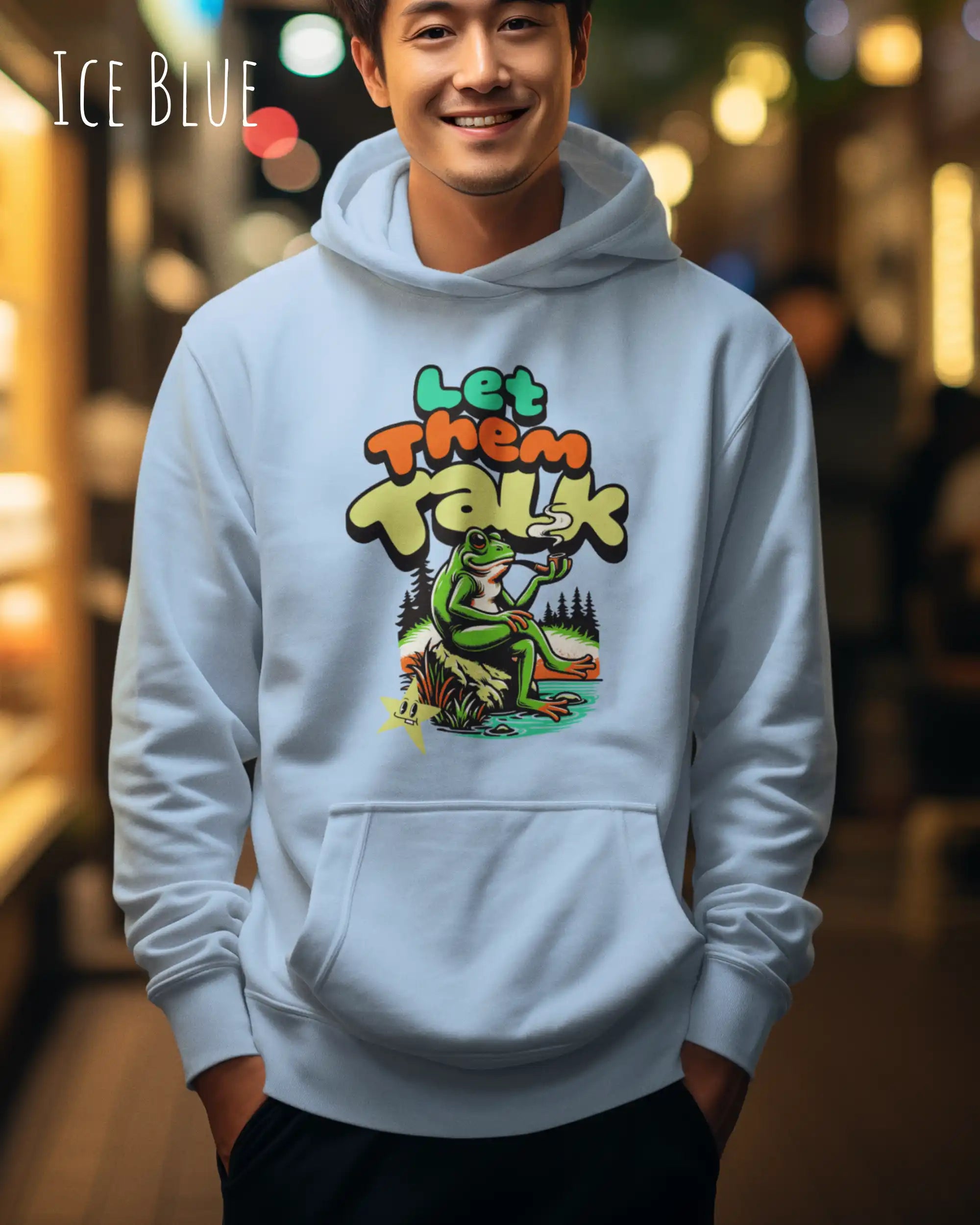 die Abbildung zeigt einen mann, der einen Oversized Design-Hoodie in der farbe ice blue und mit dem humorvollen motiv "let them talk" trägt.