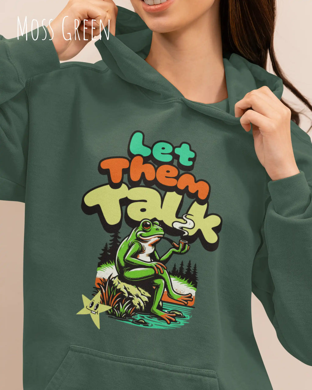 die Abbildung zeigt eine frau, die einen Oversized Design-Hoodie in der farbe mopst green und mit dem humorvollen motiv "let them talk" trägt.