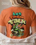 das bild zeigt eine frau, die ein damen design-t-shirt in der farbe orange mit dem backprint Motiv "let them talk" trägt,