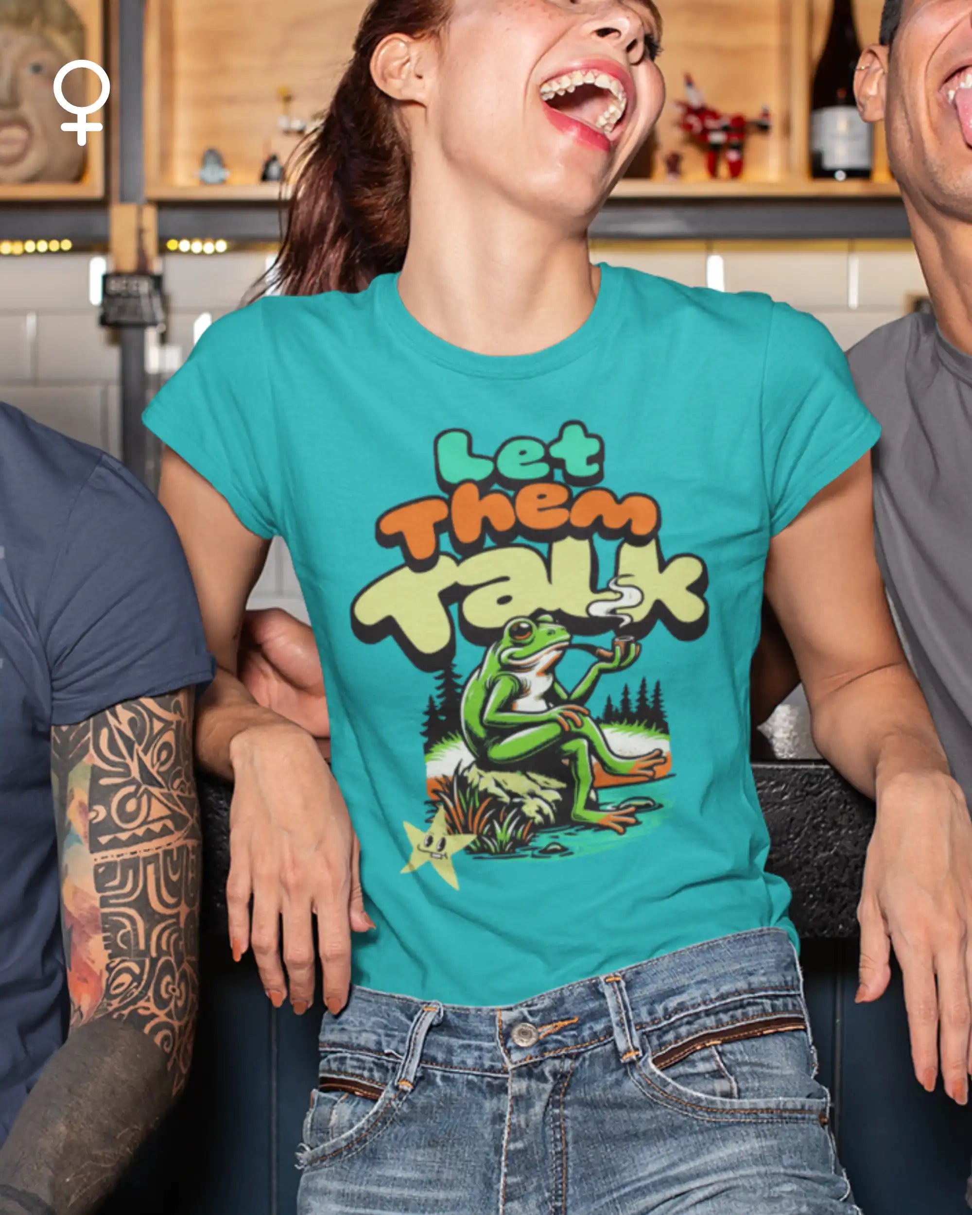 das bild zeigt eine lachende  frau, die ein damen design-t-shirt  mit dem Motiv "let them talk" trägt,