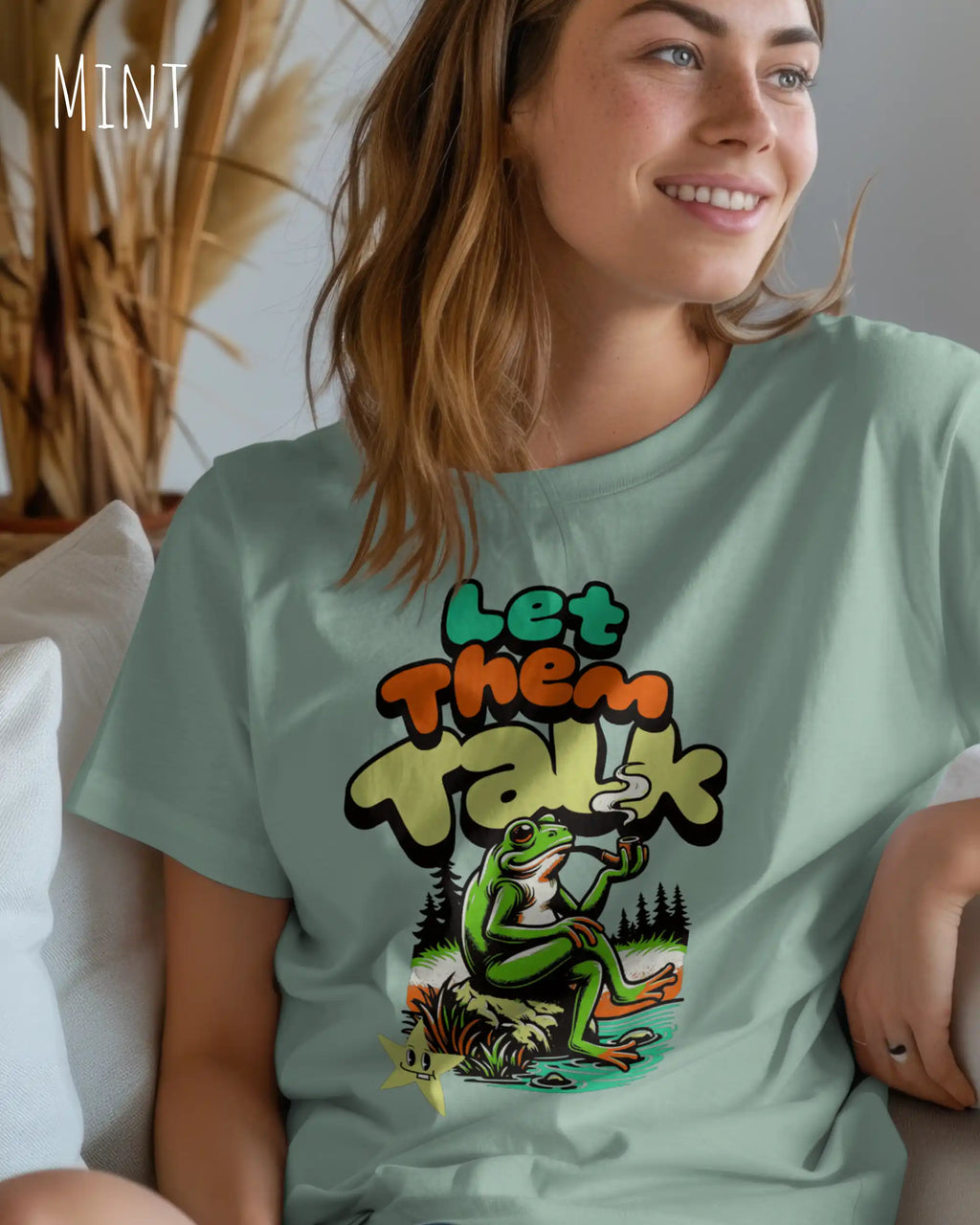 junge frau trägt ein Design-T-Shirt in der farbe mint mit dem humorvollen Motiv "Let them talk" 