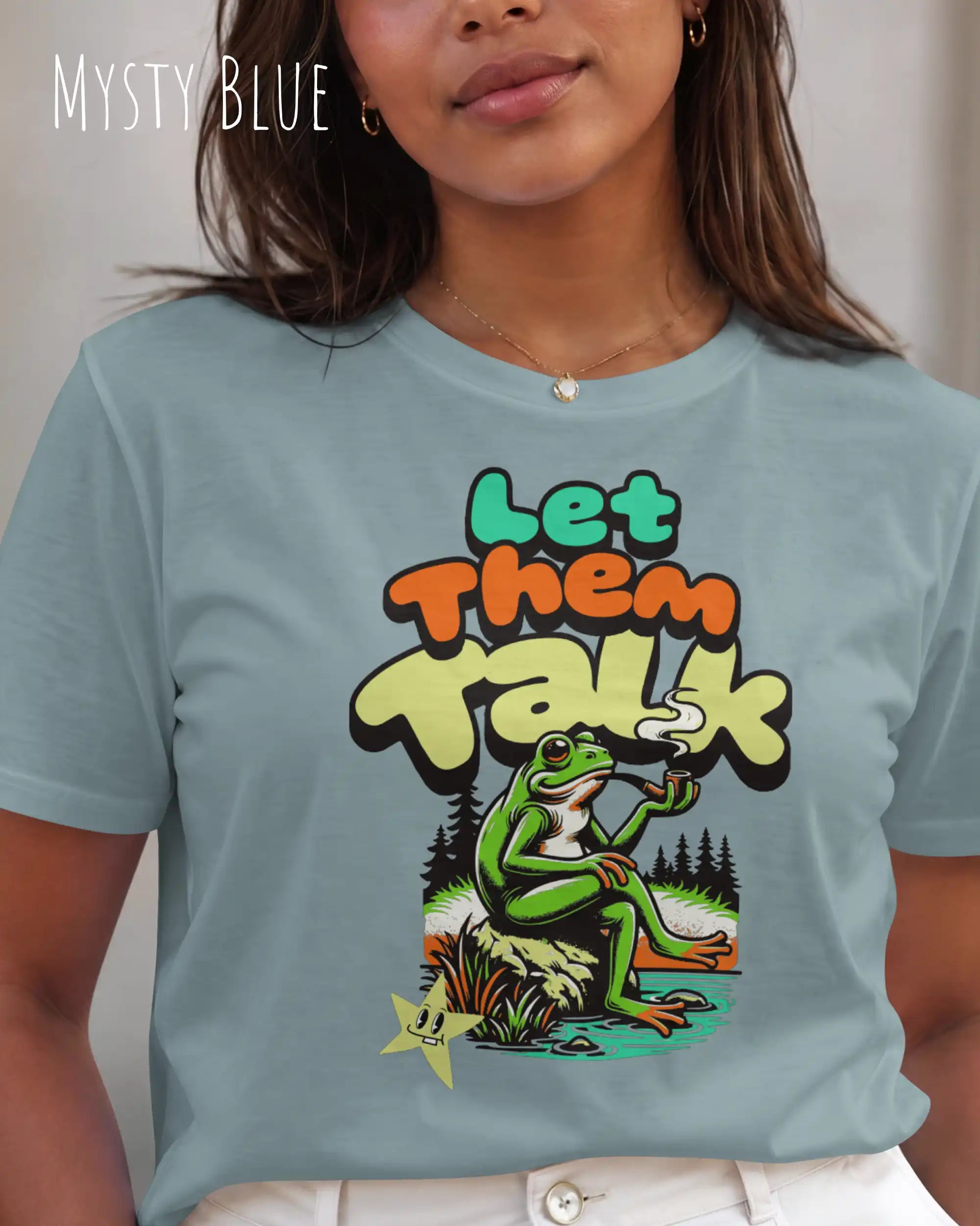 eine frau trägt ein Design-T-Shirt in der farbe mysty blue mit dem humorvollen Motiv "Let them talk" 