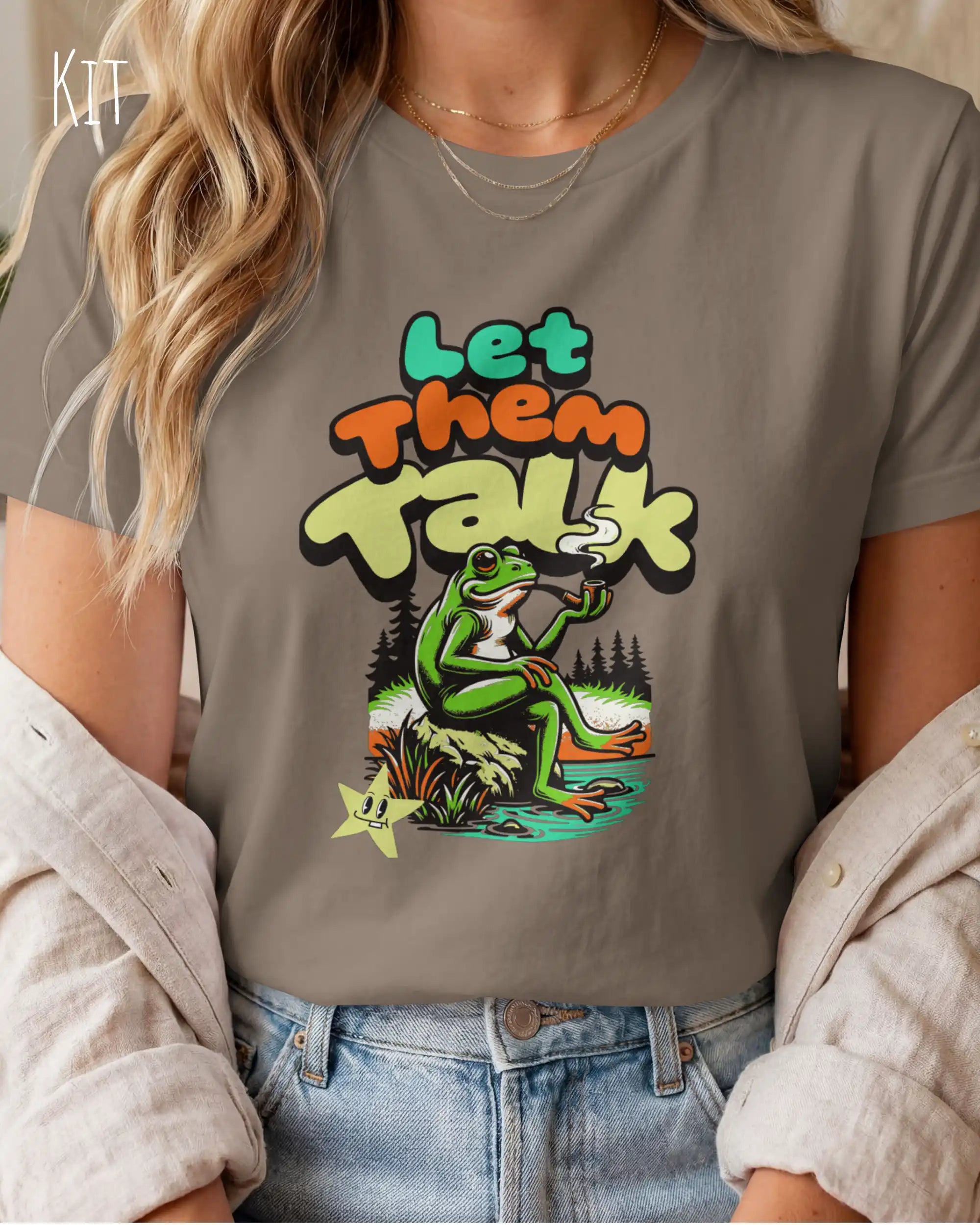 das Bild zeigt eine frau, die ein feminines design-t-shirt in der farbe kit mit dem humorvollen design "LET THEM TALK" trägt.