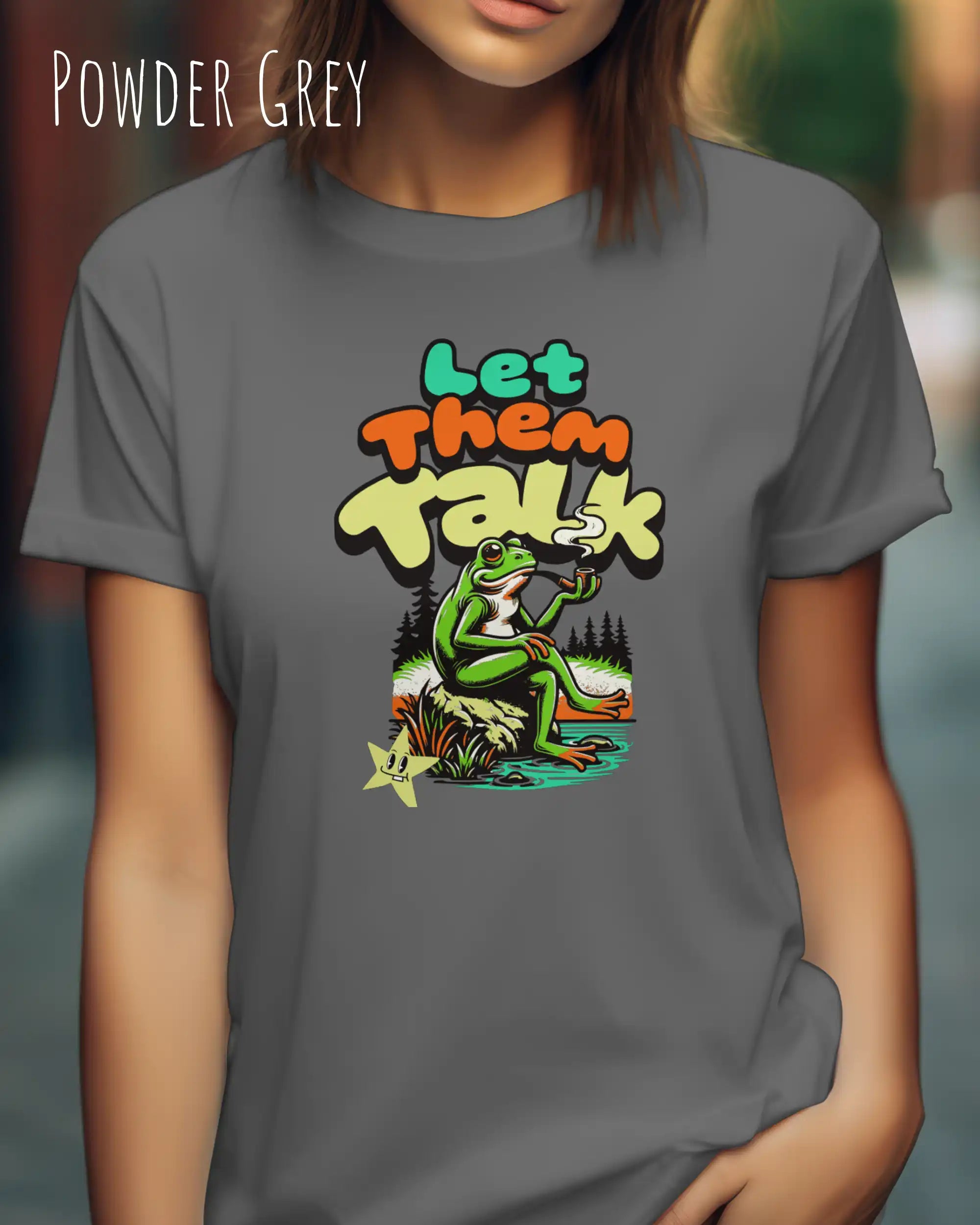 Dieses Bild zeigt eine frau, die ein feminines design-t-shirt in der farbe powder grey mit dem humorvollen design "LET THEM TALK" trägt.