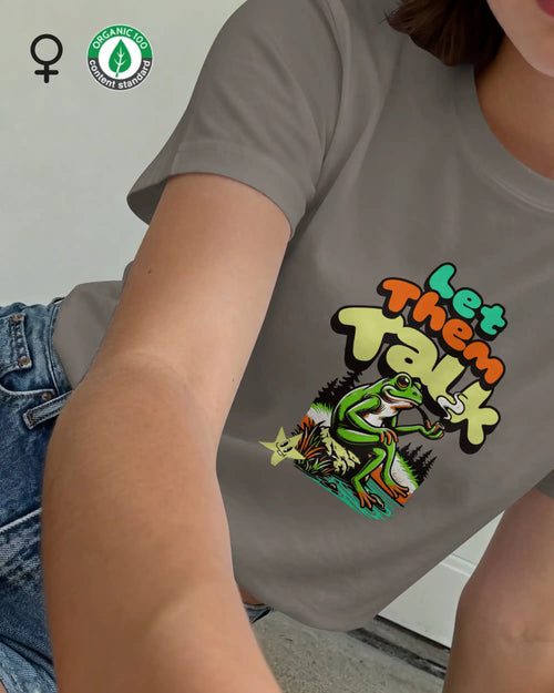 Dieses Bild zeigt eine frau, die ein feminines design-t-shirtaus bio baumwolle mit dem humorvollen design "LET THEM TALK" trägt.