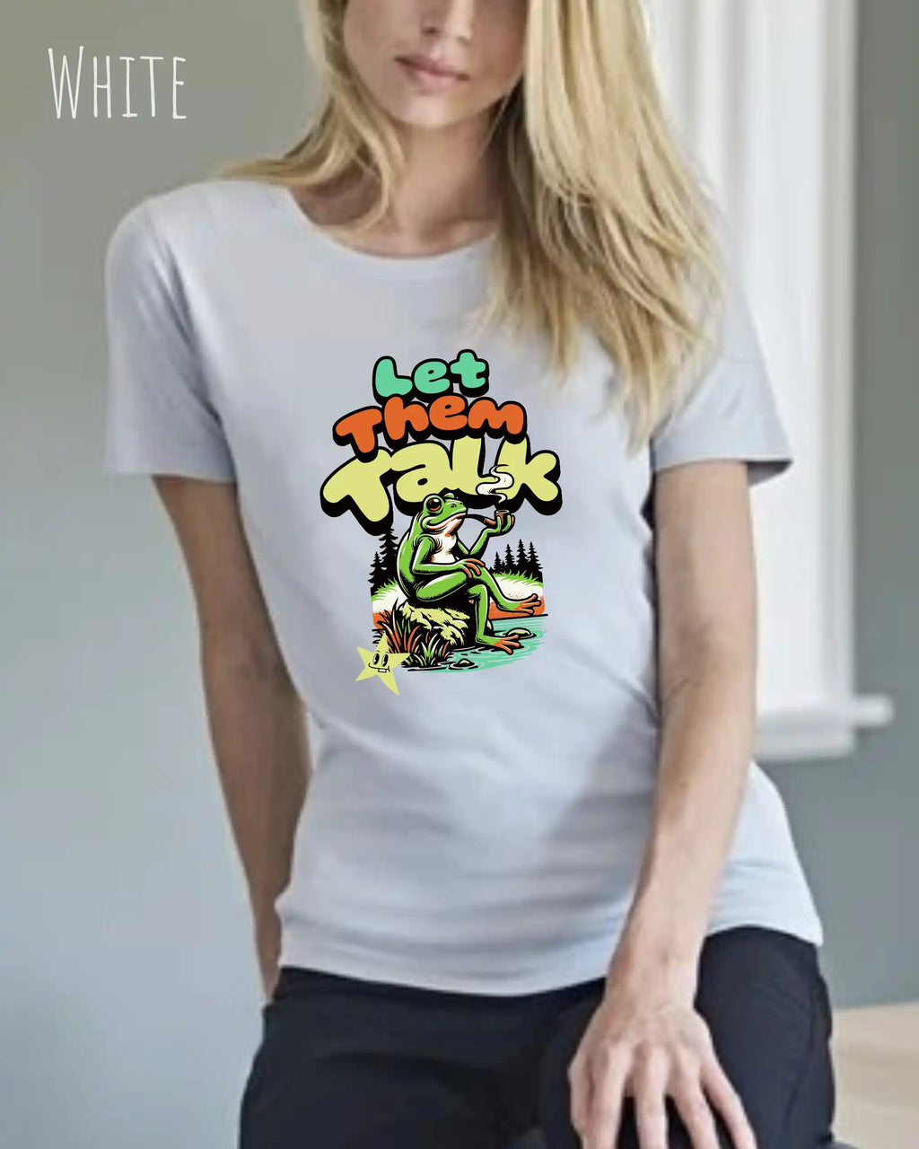 Dieses Bild zeigt eine blonde  frau, die ein feminines design-t-shirt in der farbe white mit dem humorvollen design "LET THEM TALK" trägt.