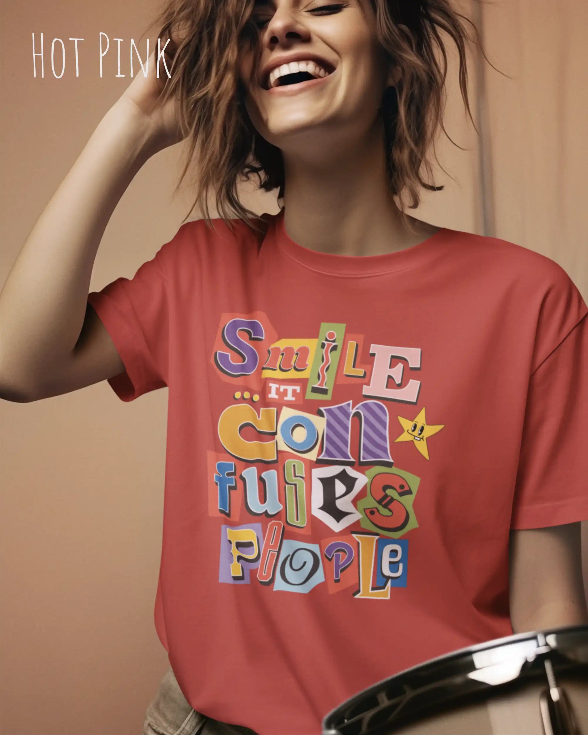 Eine Frau trägt ein Design-T-Schirt in der  Farbe hot pink mit der Grafik Smile it confuses people.