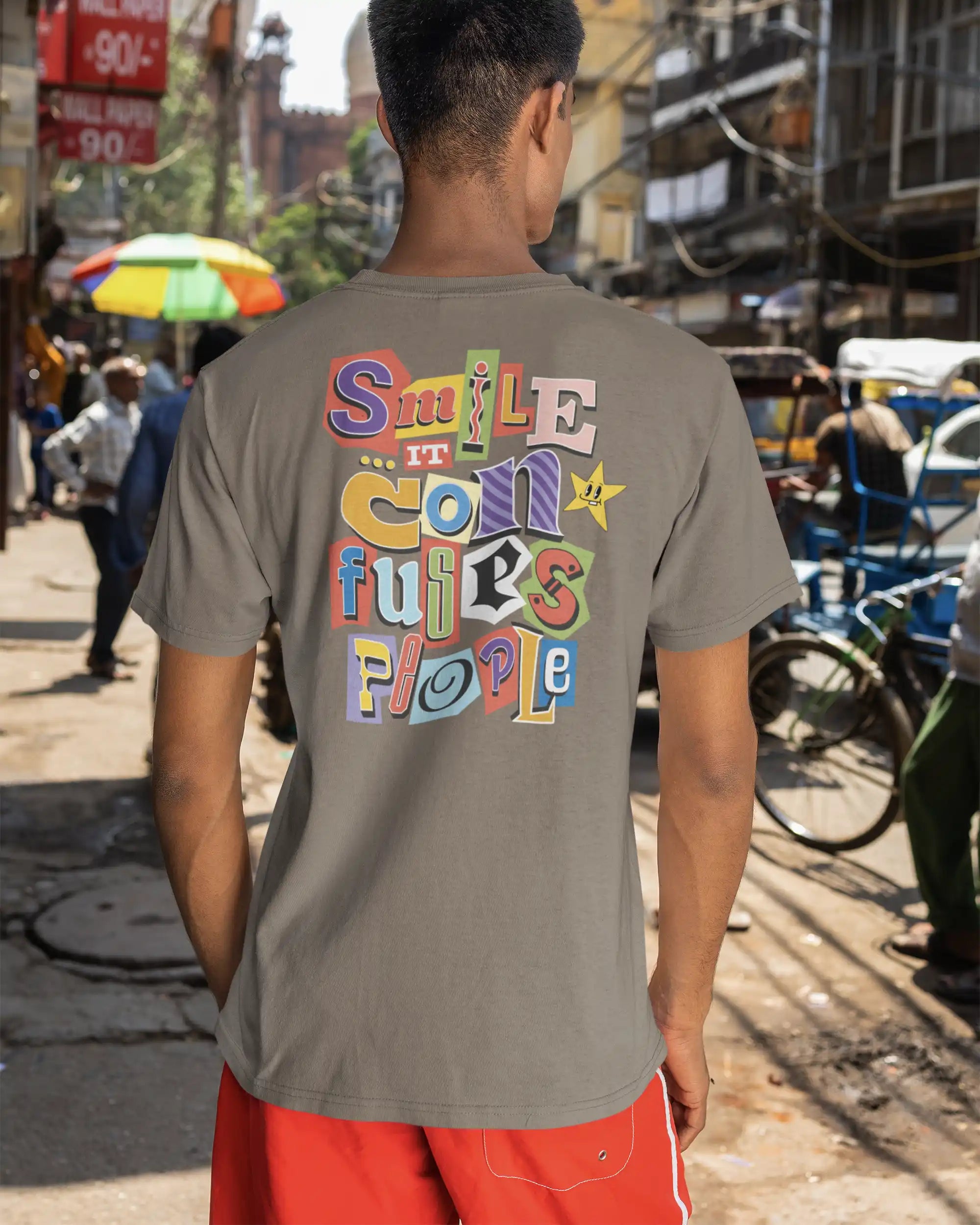 Ein Mann trägt ein  Design-T-Schirt in der  Farbe moccabrown mit der backprint Grafik Smile it confuses people
