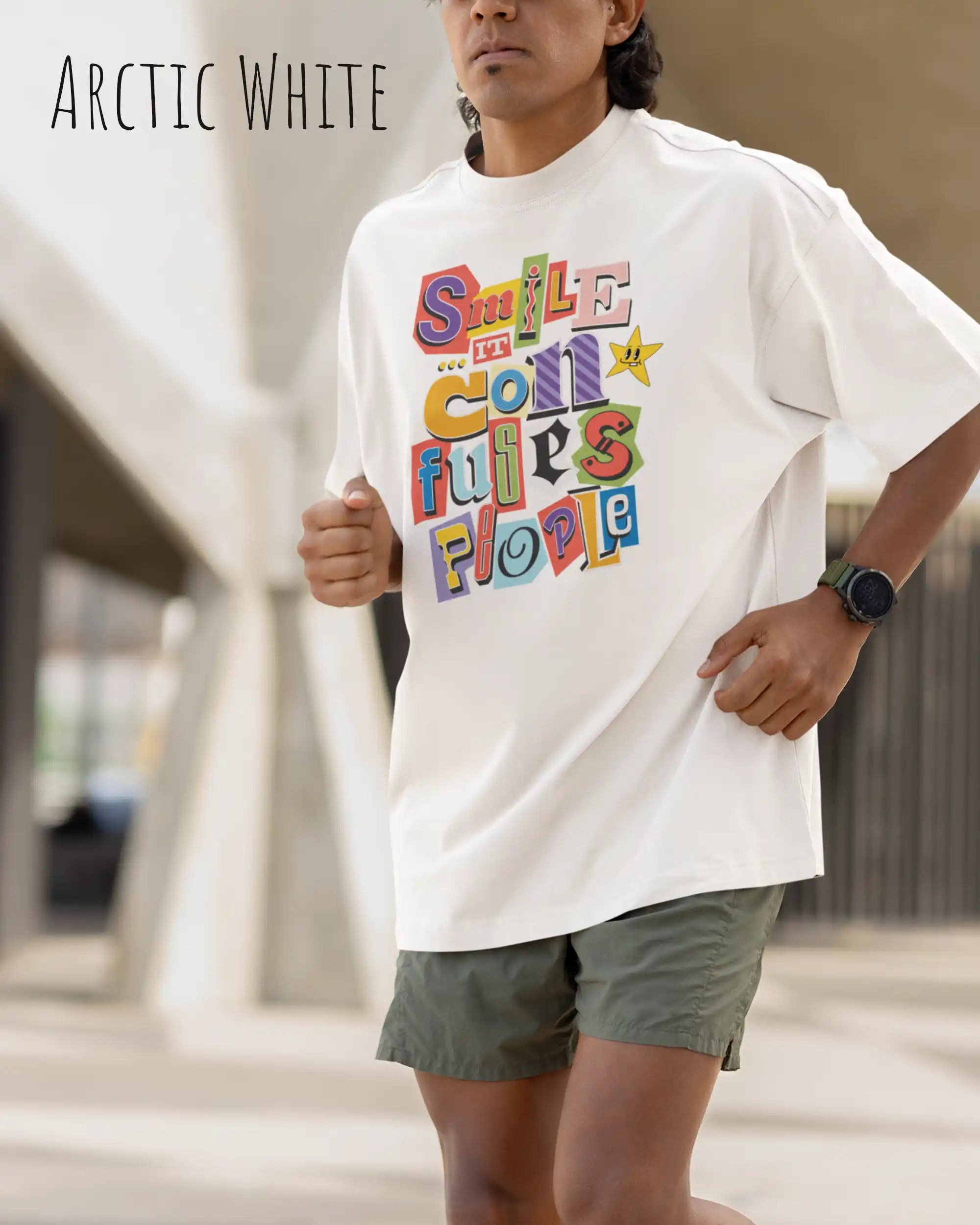 ein  mann trögt ein  heavywight oversized t-shirt  in der farbe arctic white  mit dem design smile it confuses people.