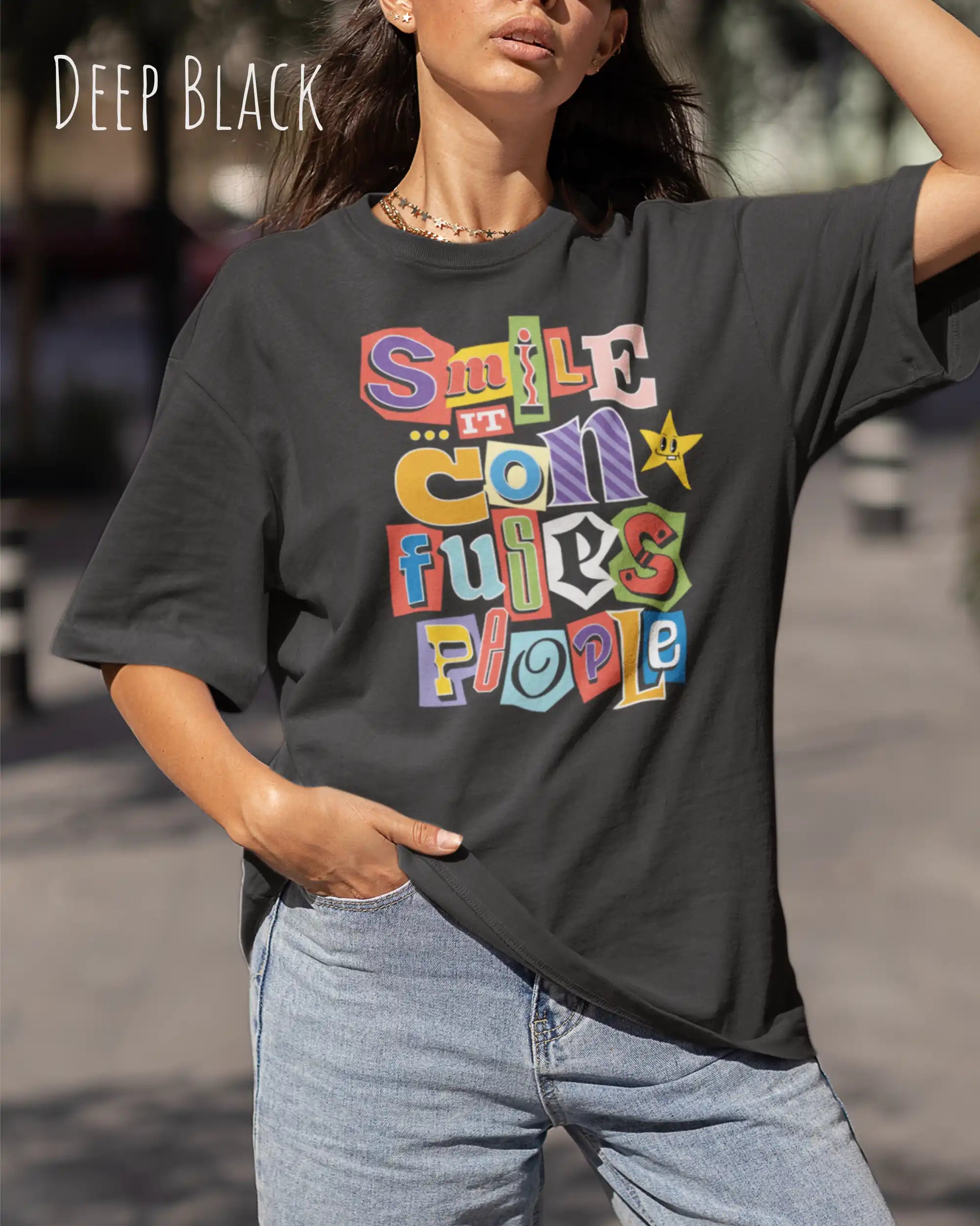 Junge frau trögt ein  heavywight oversized t-shirt  in der farbe deep black  mit dem design smile it confuses people.