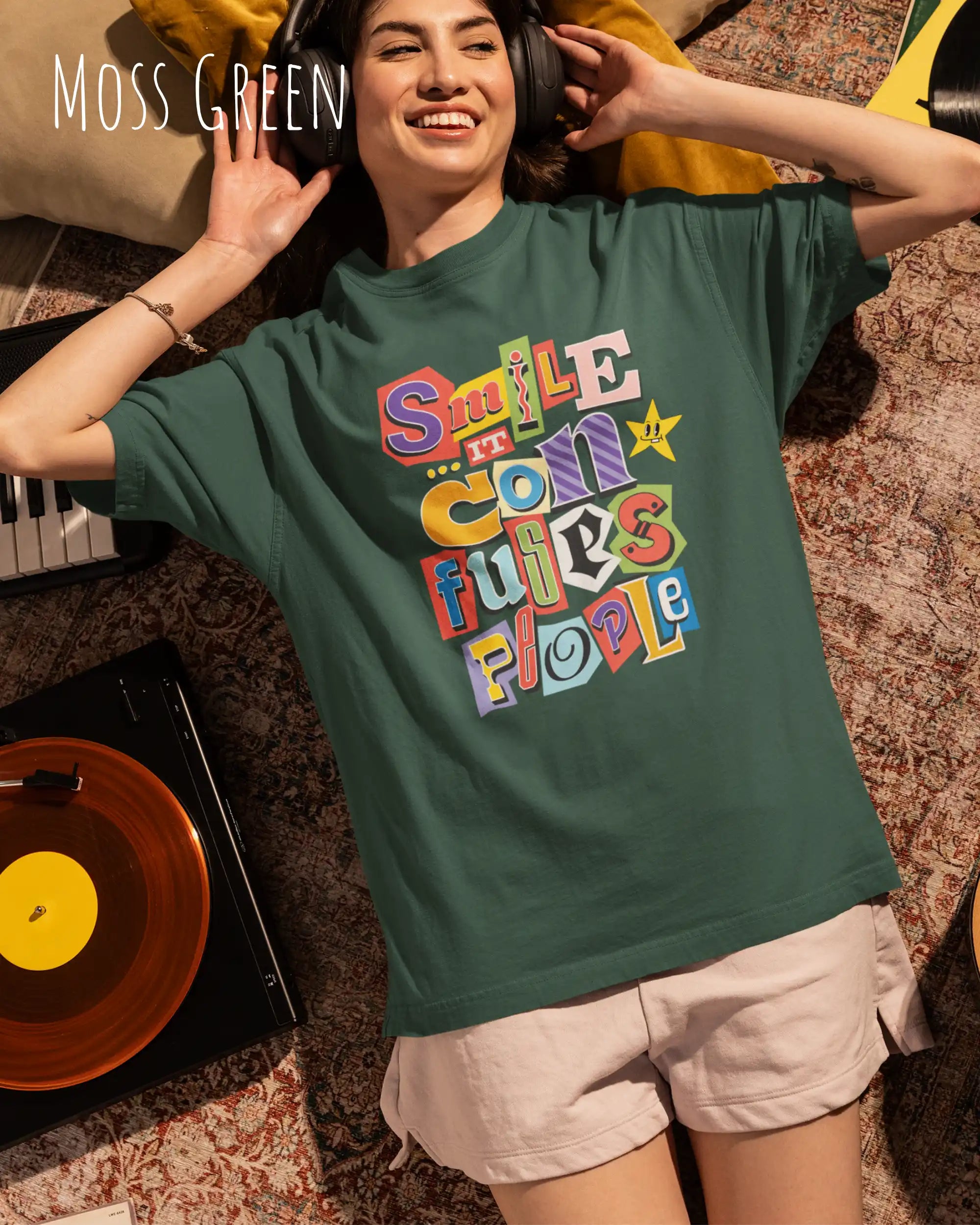 Junge frau trögt ein  heavywight oversized t-shirt  in der farbe moss green  mit dem design smile it confuses people.