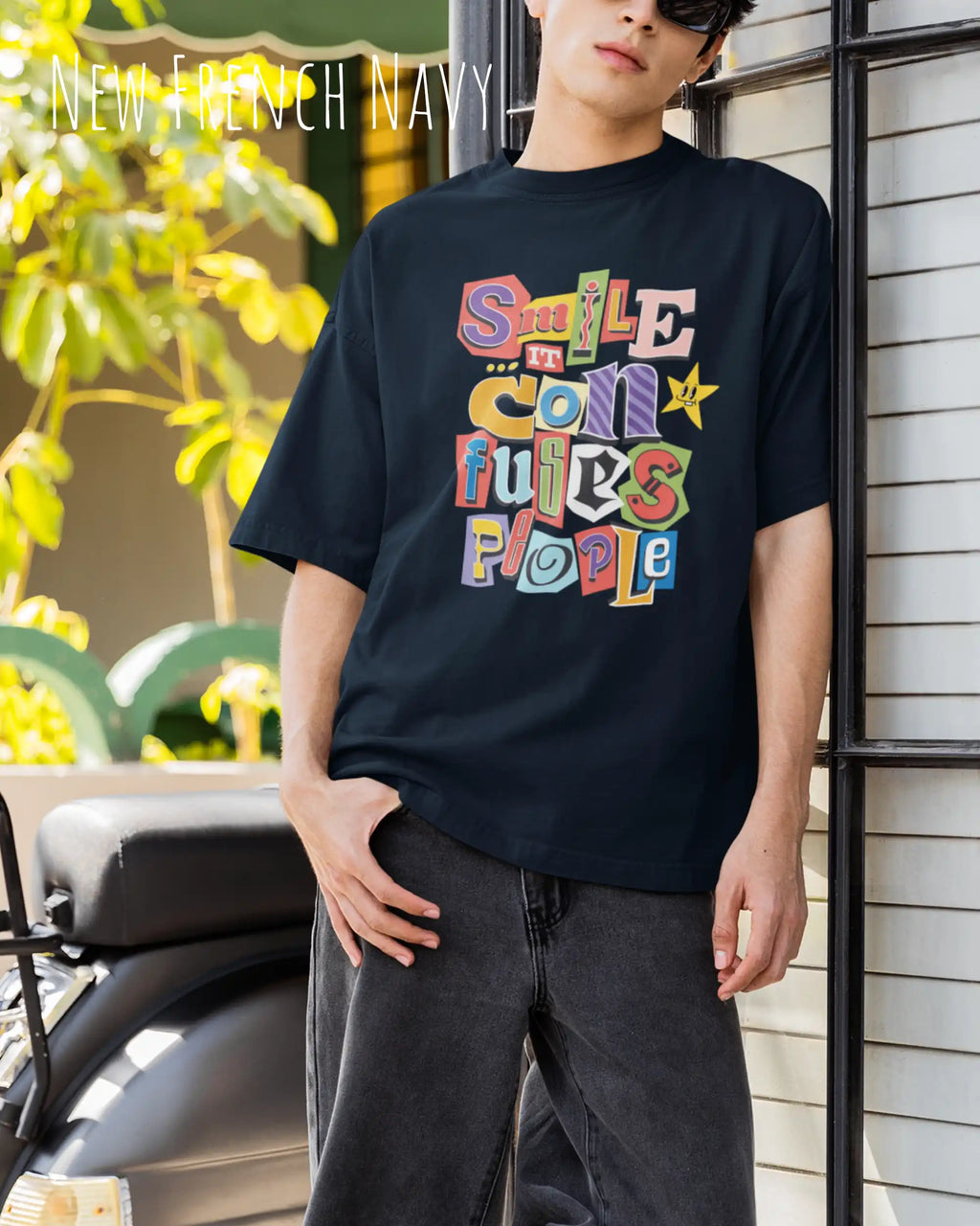 Junger mann trögt ein  heavywight oversized t-shirt  in der farbe dnew french navy mit dem design smile it confuses people.