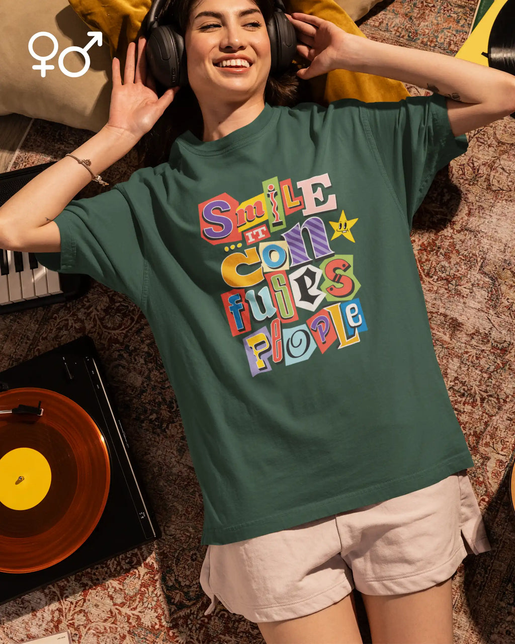Junge frau trögt ein  heavywight oversized  unisex t-shirt  in der farbe moss green  mit dem design smile it confuses people.
