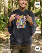 das bild zeigt eine frau, die einen leicht taillierten damen design hoodie in der farbe deep black  und mit dem farbenfrohen motiv "smile ... it confuses people" trägt.