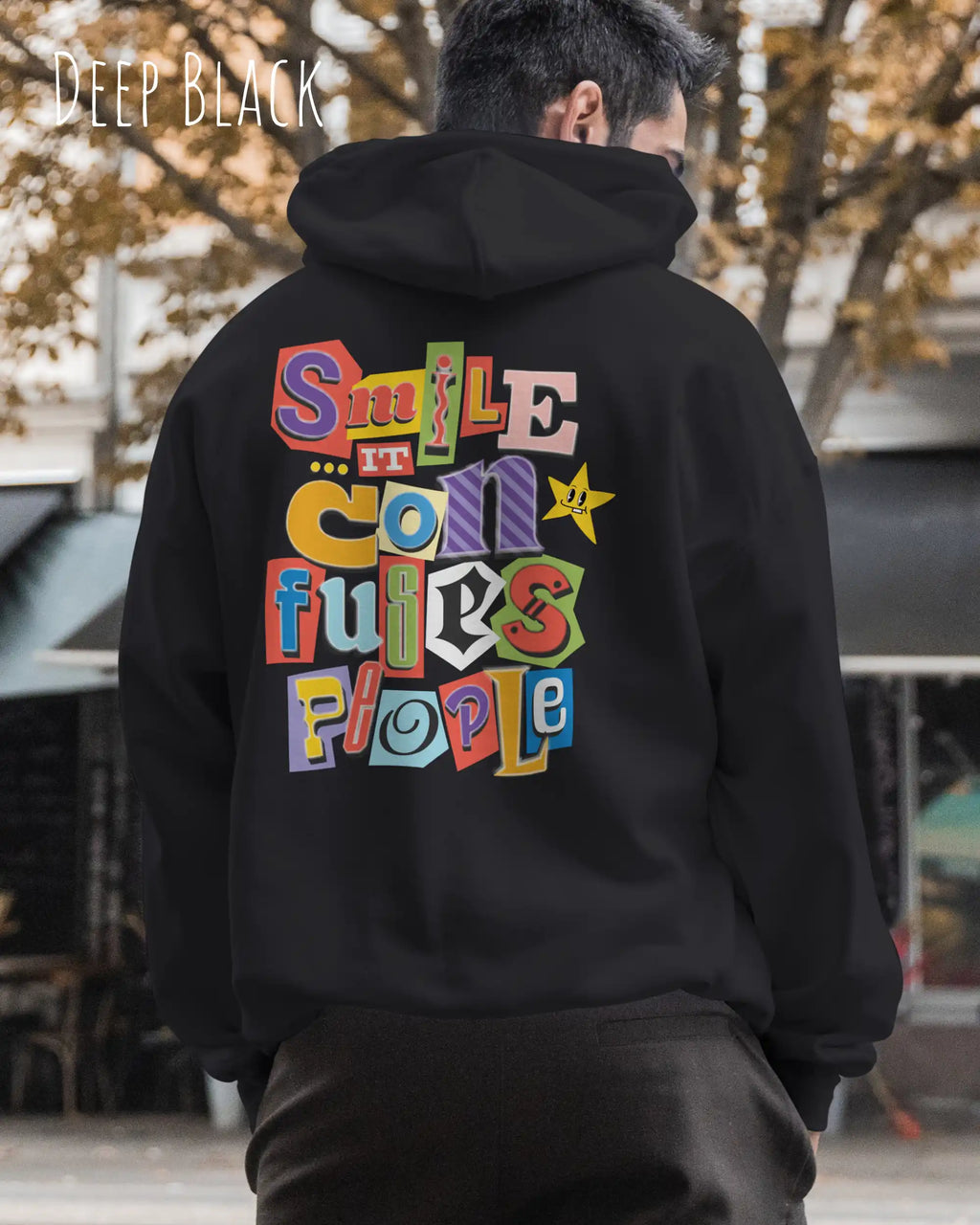 ein mann trägt einen Oversized Design-Hoodie JH111 in  deep black mit der farbenfrohen grafik "Smile ... it confuses people" hinten auf dem rücken.