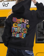 eine frau trägt einen Oversized Design-Hoodie in unisex mit der farbenfrohen grafik "Smile ... it confuses people",