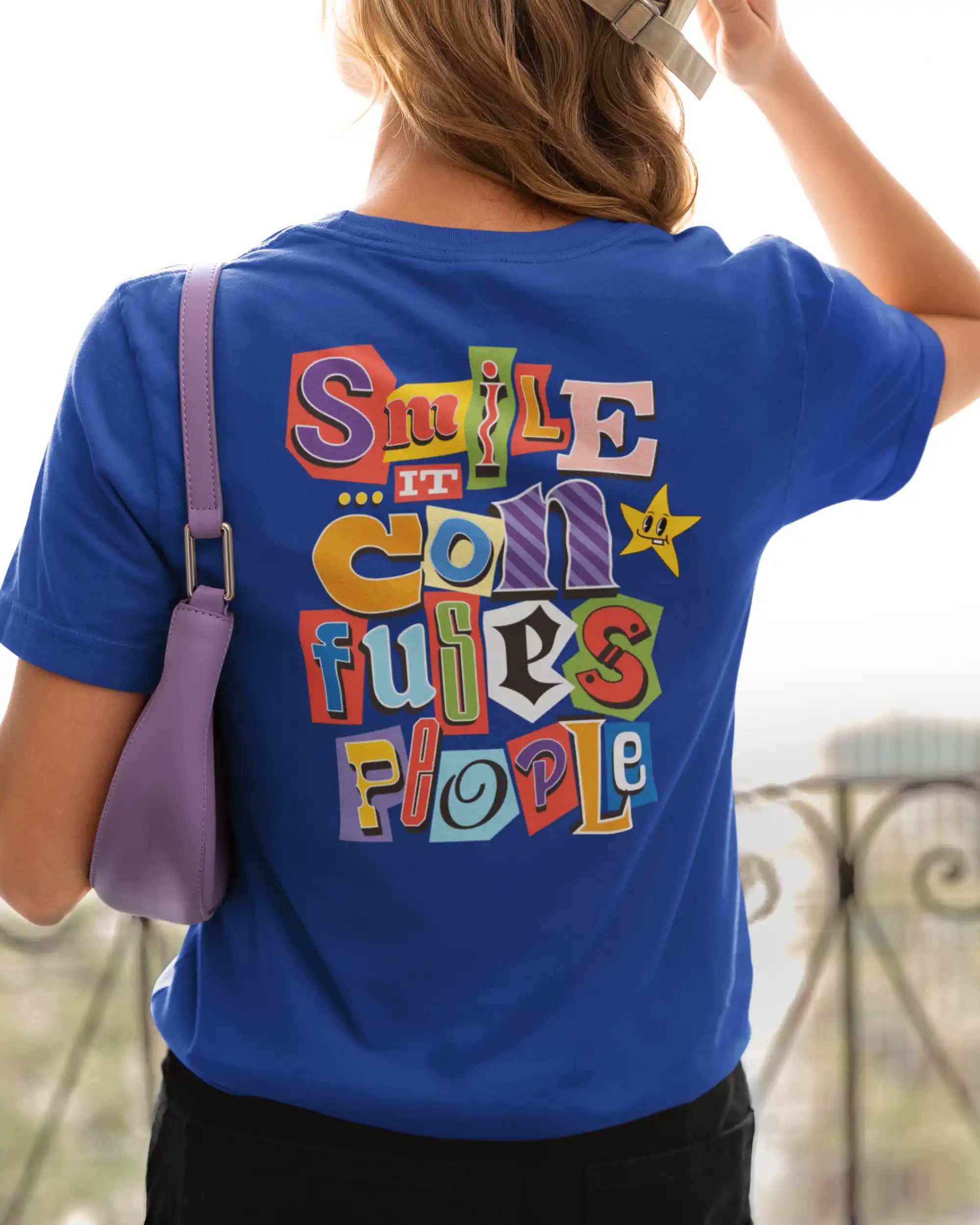 eine frau trägt ein Design-T-Shirt  in royal blue  mit dem backprint  "Smile, it confuses people".