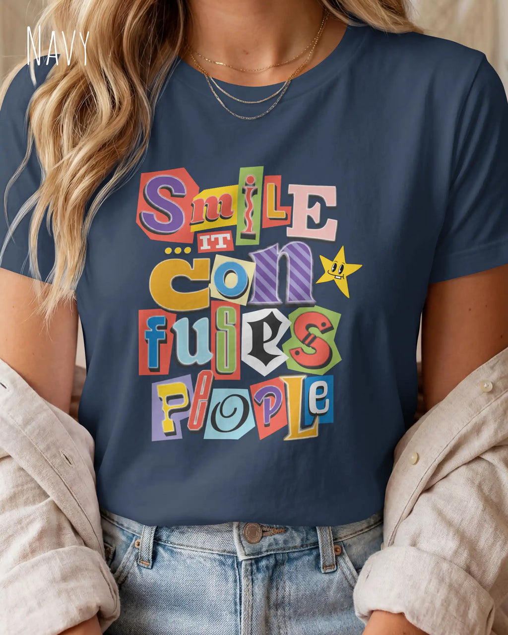 Die Abbildung zeigt eine frau, die ein feminines design-t-shirt in der farbe navy mit der farbenfrohen grafik "smile ... it confuses people" trägt.