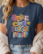 Die Abbildung zeigt eine frau, die ein feminines design-t-shirt in der farbe navy mit der farbenfrohen grafik "smile ... it confuses people" trägt.