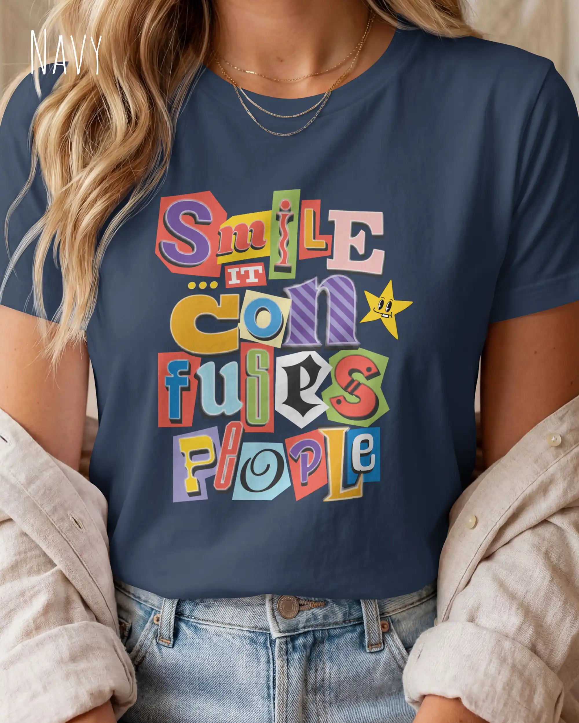Die Abbildung zeigt eine frau, die ein feminines design-t-shirt in der farbe navy mit der farbenfrohen grafik "smile ... it confuses people" trägt.