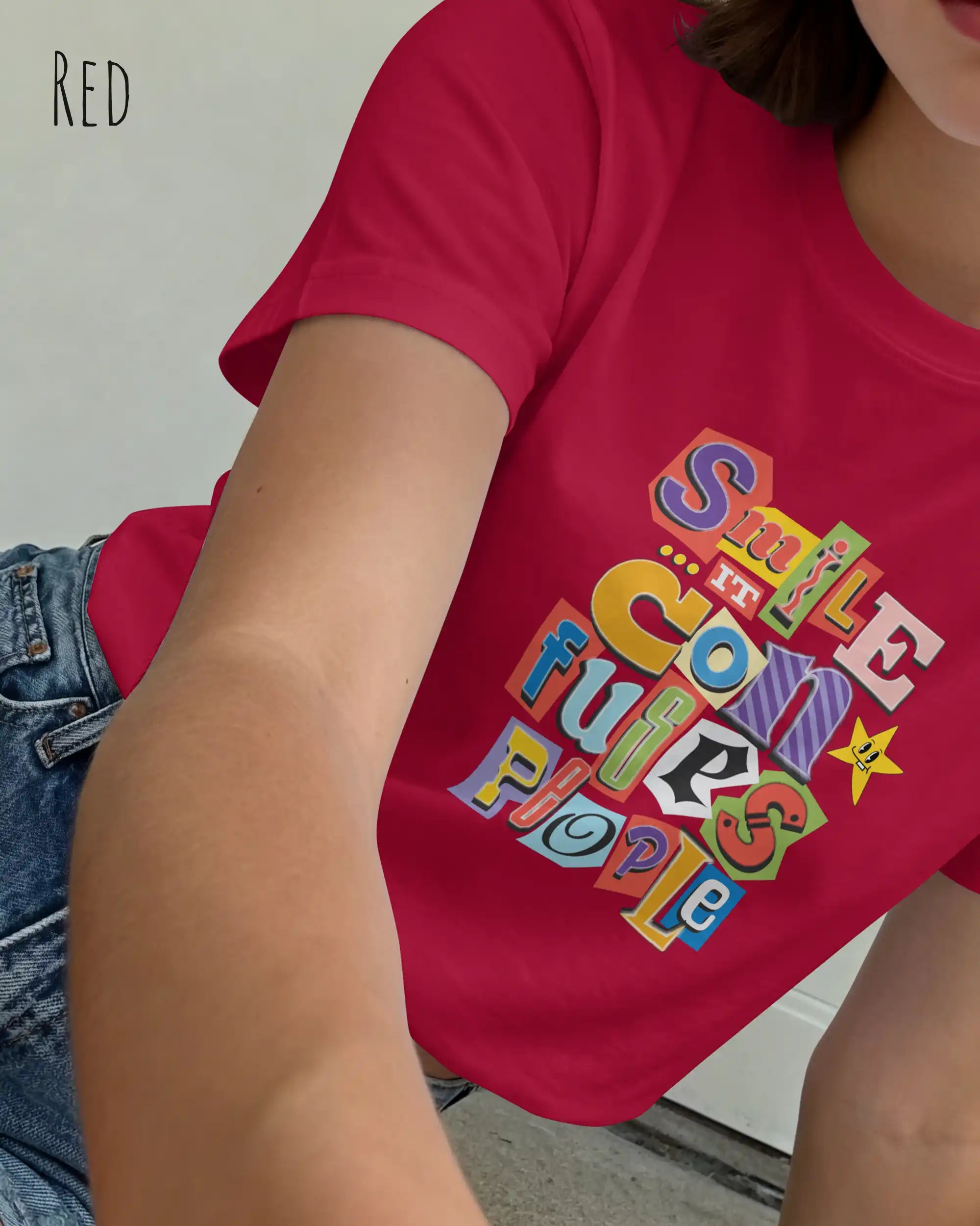 Die Abbildung zeigt eine frau, die ein feminines design-t-shirt in der farbe red mit der farbenfrohen grafik "smile ... it confuses people" trägt.